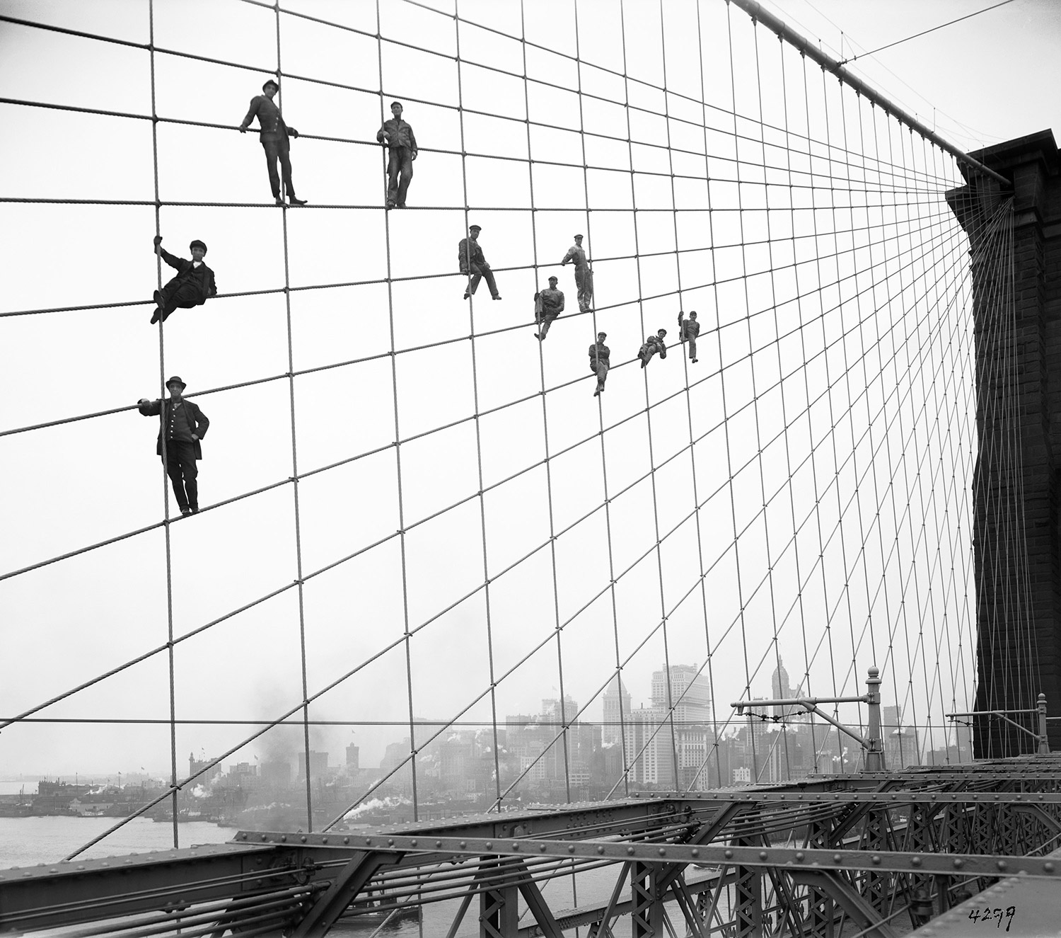 Bridge painters perch on the suspension wires of the Brooklyn Bridge, October 7, 1914.