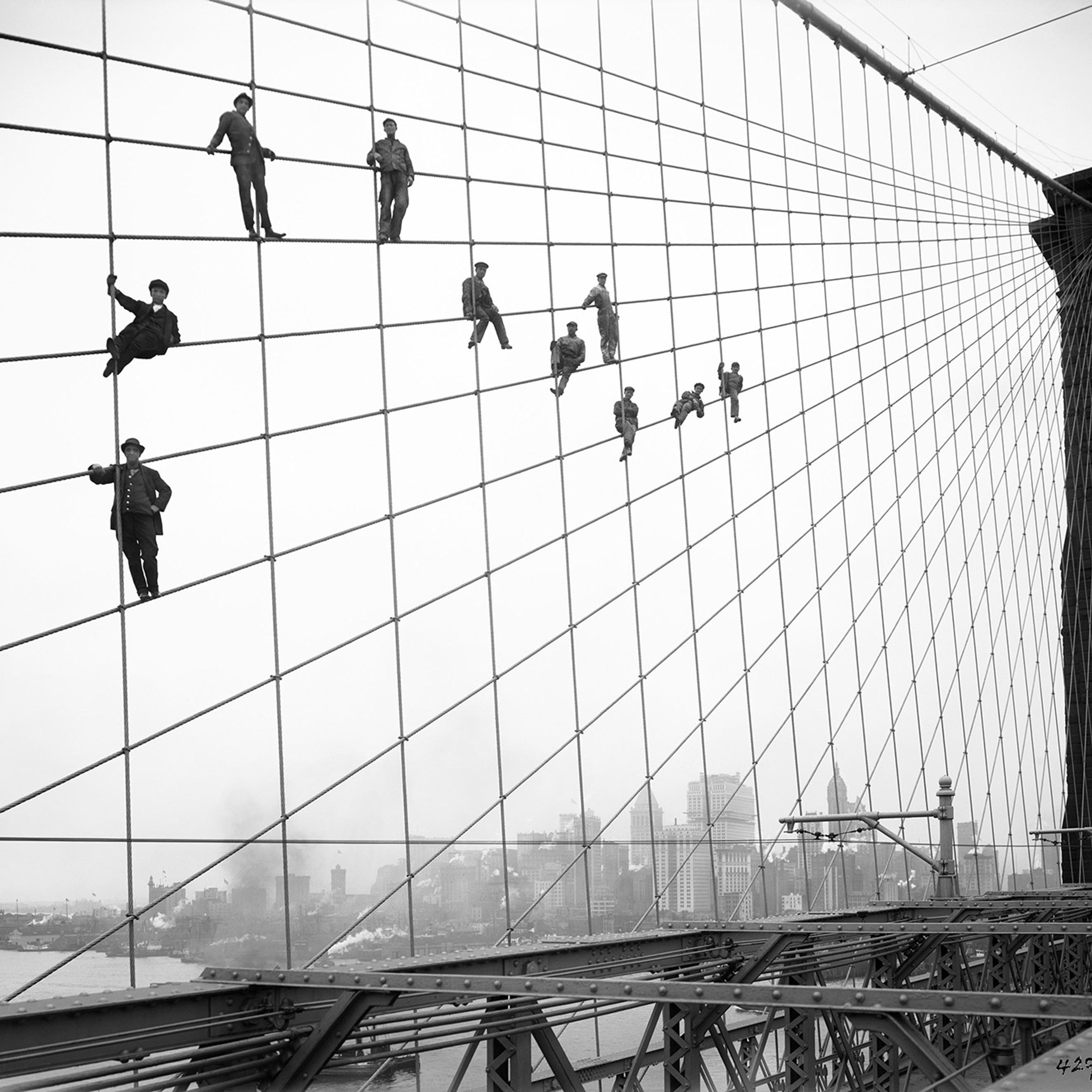 Bridge painters perch on the suspension wires of the Brooklyn Bridge, October 7, 1914.