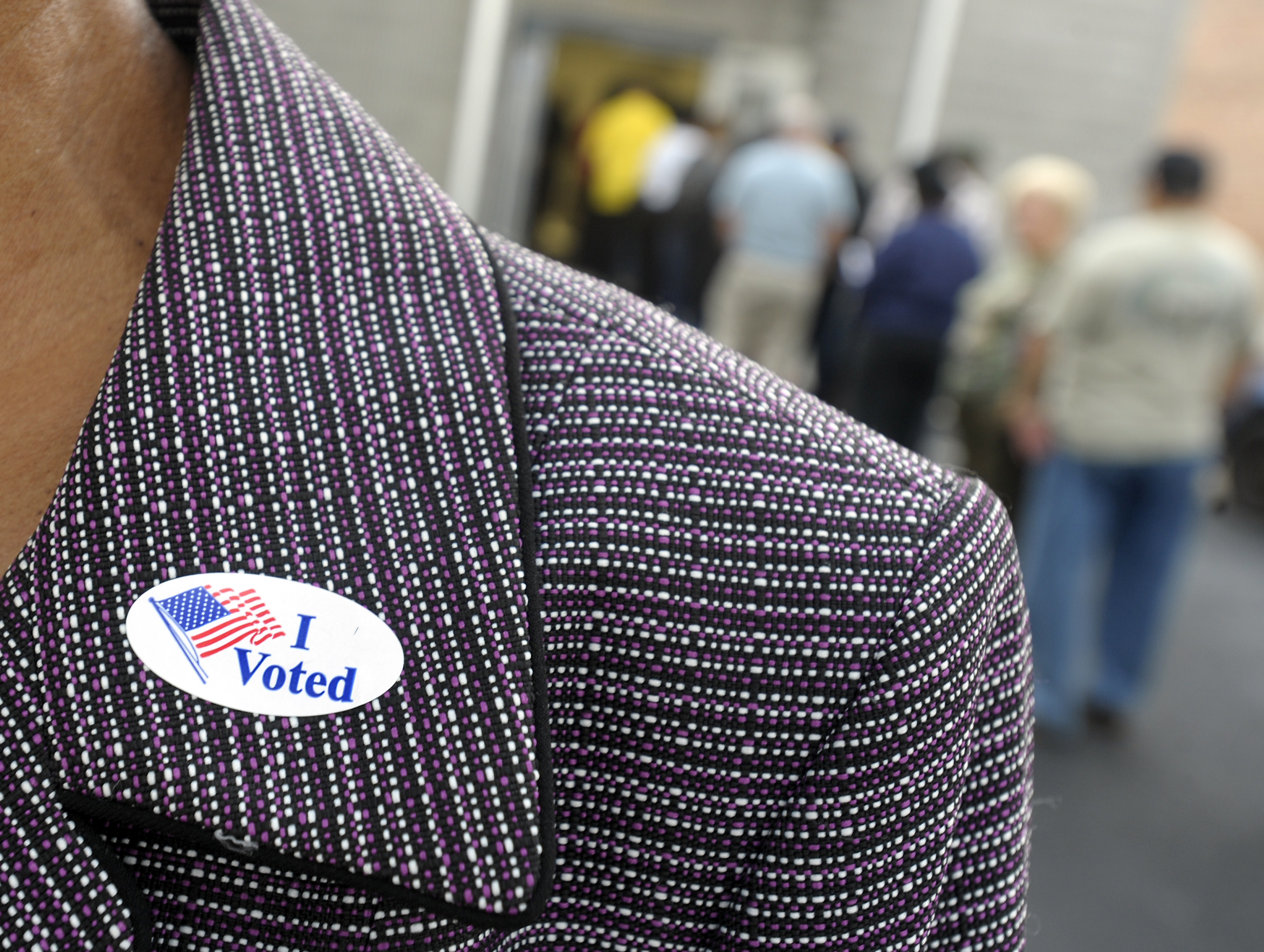 A voter displays their "I Voted" sticker on their lapel after voting as others wait in line for the first day of Early Voting on October 18, 2012 in Wilson, North Carolina.