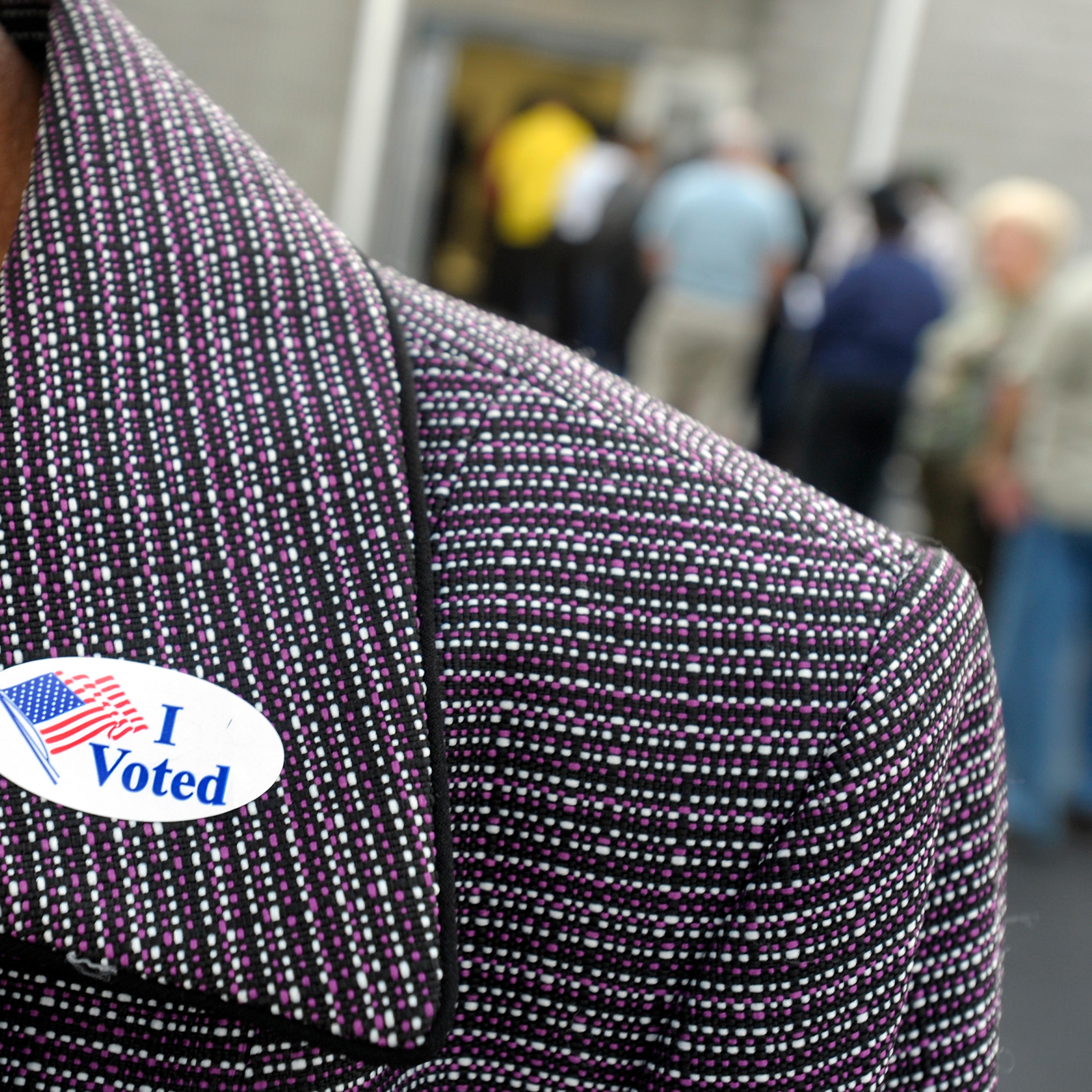A voter displays their "I Voted" sticker on their lapel after voting as others wait in line for the first day of Early Voting on October 18, 2012 in Wilson, North Carolina.
