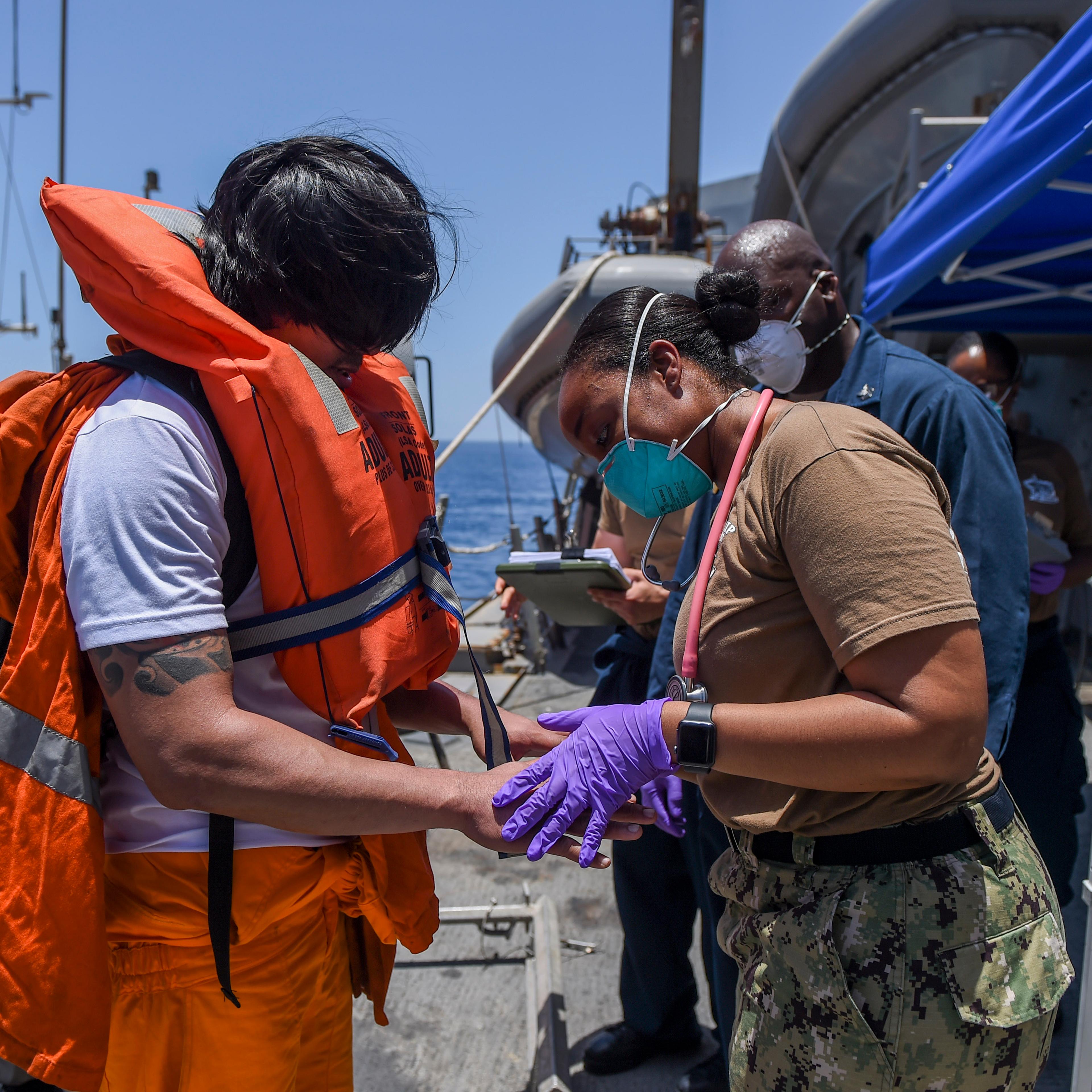 Sailors aboard the Arleigh Burke-class guided-missile destroyer USS Bainbridge render aid to the crew of the M/V Kokuka Courageous on June 13, 2019.