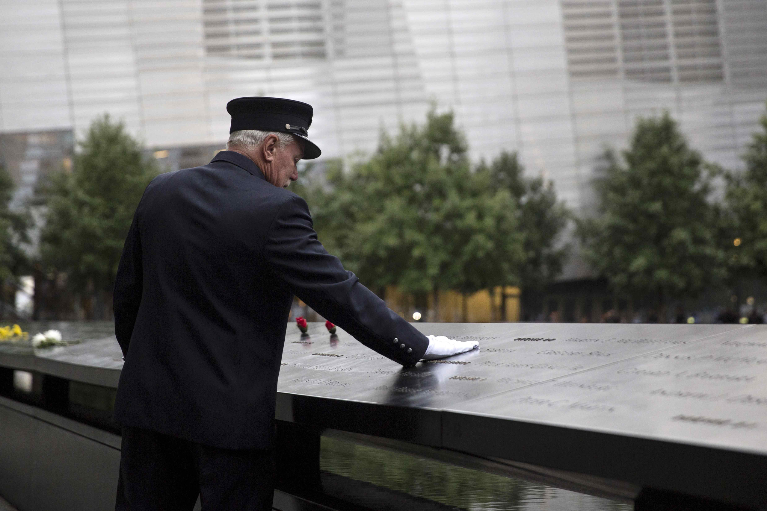 A member of the New York Fire Department places his hand on the memorial before a ceremony marking the 14th anniversary of the 9/11 attacks, at the National September 11 Memorial and Museum in Lower Manhattan in New York September 11, 2015.