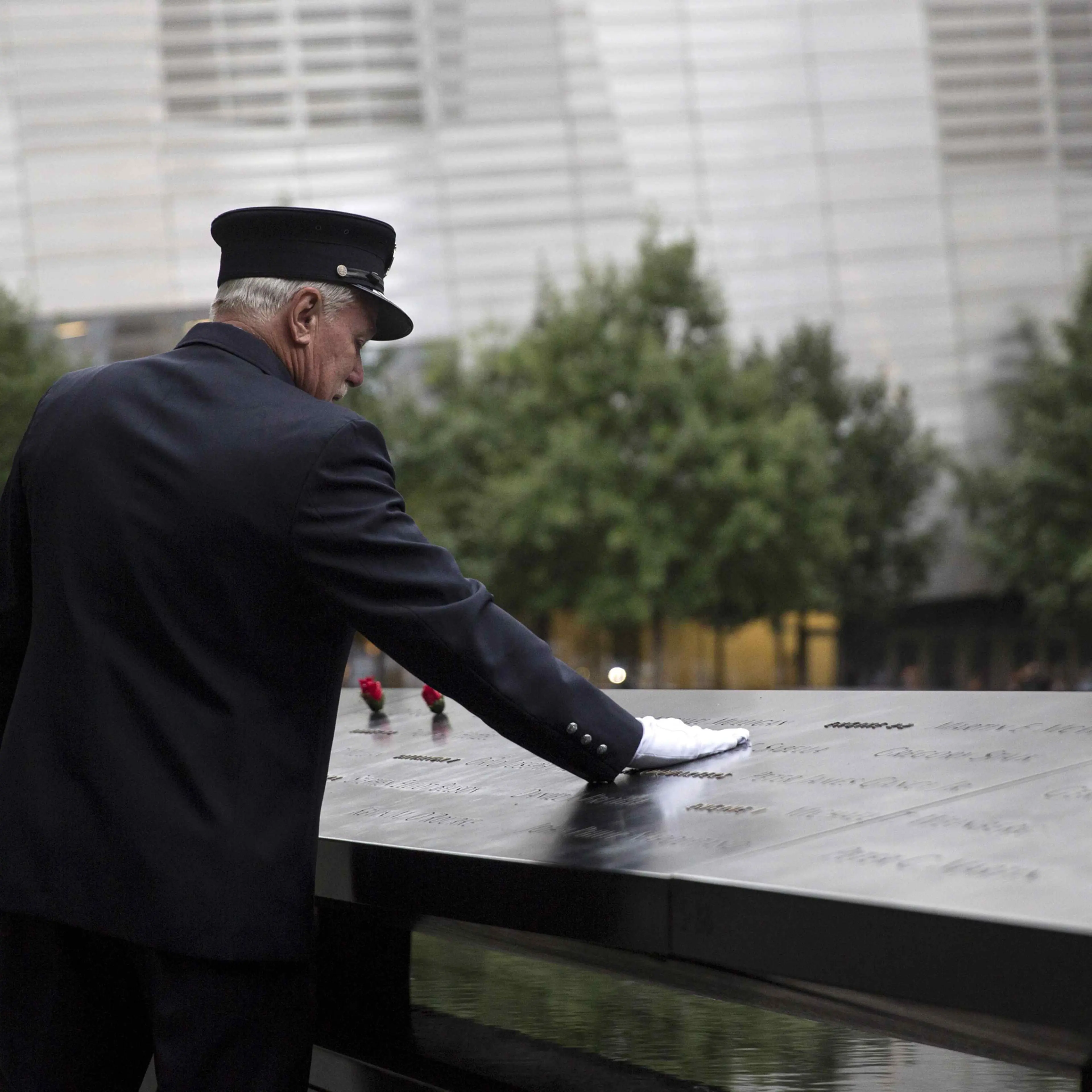 A member of the New York Fire Department places his hand on the memorial before a ceremony marking the 14th anniversary of the 9/11 attacks, at the National September 11 Memorial and Museum in Lower Manhattan in New York September 11, 2015.