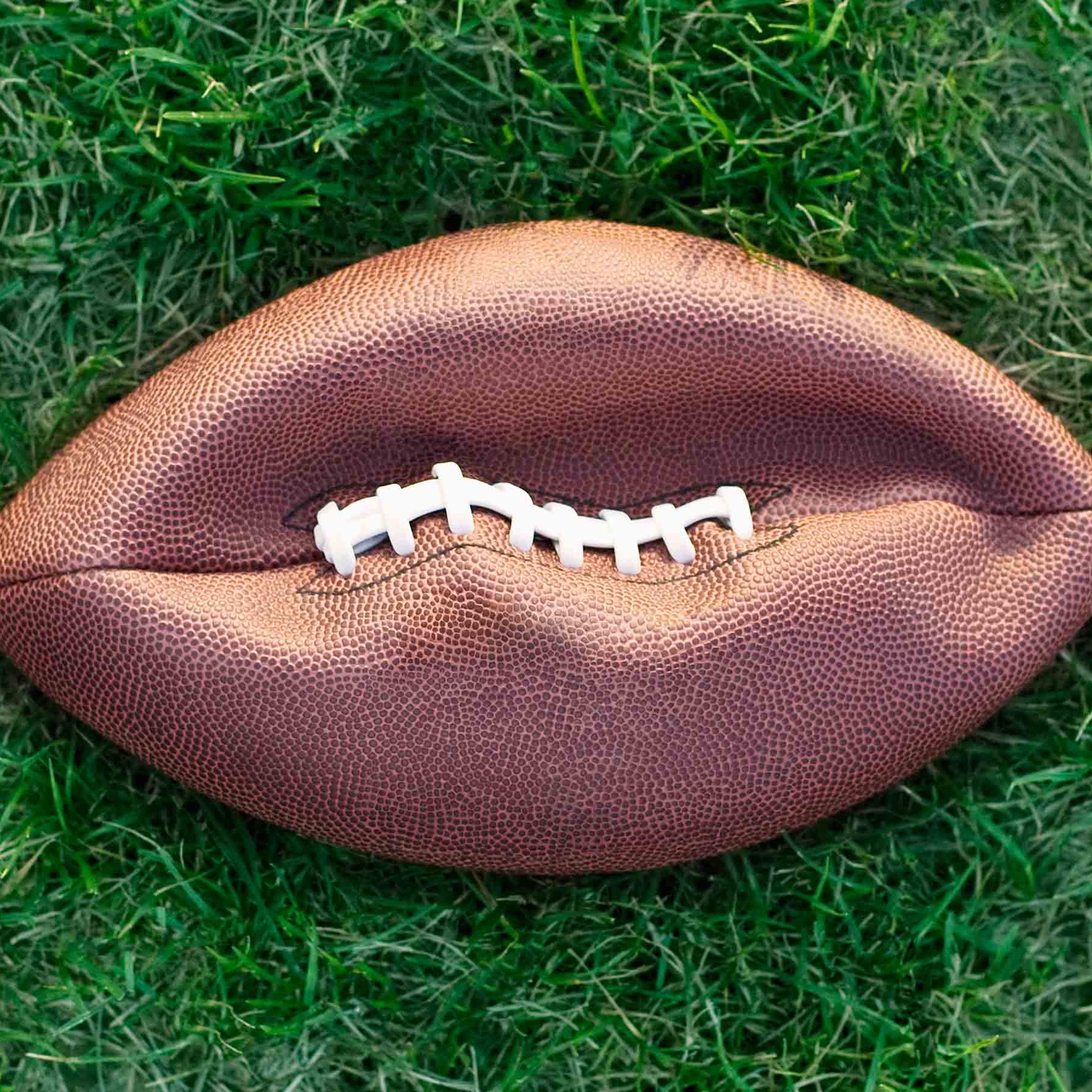 Deflated American football on grass