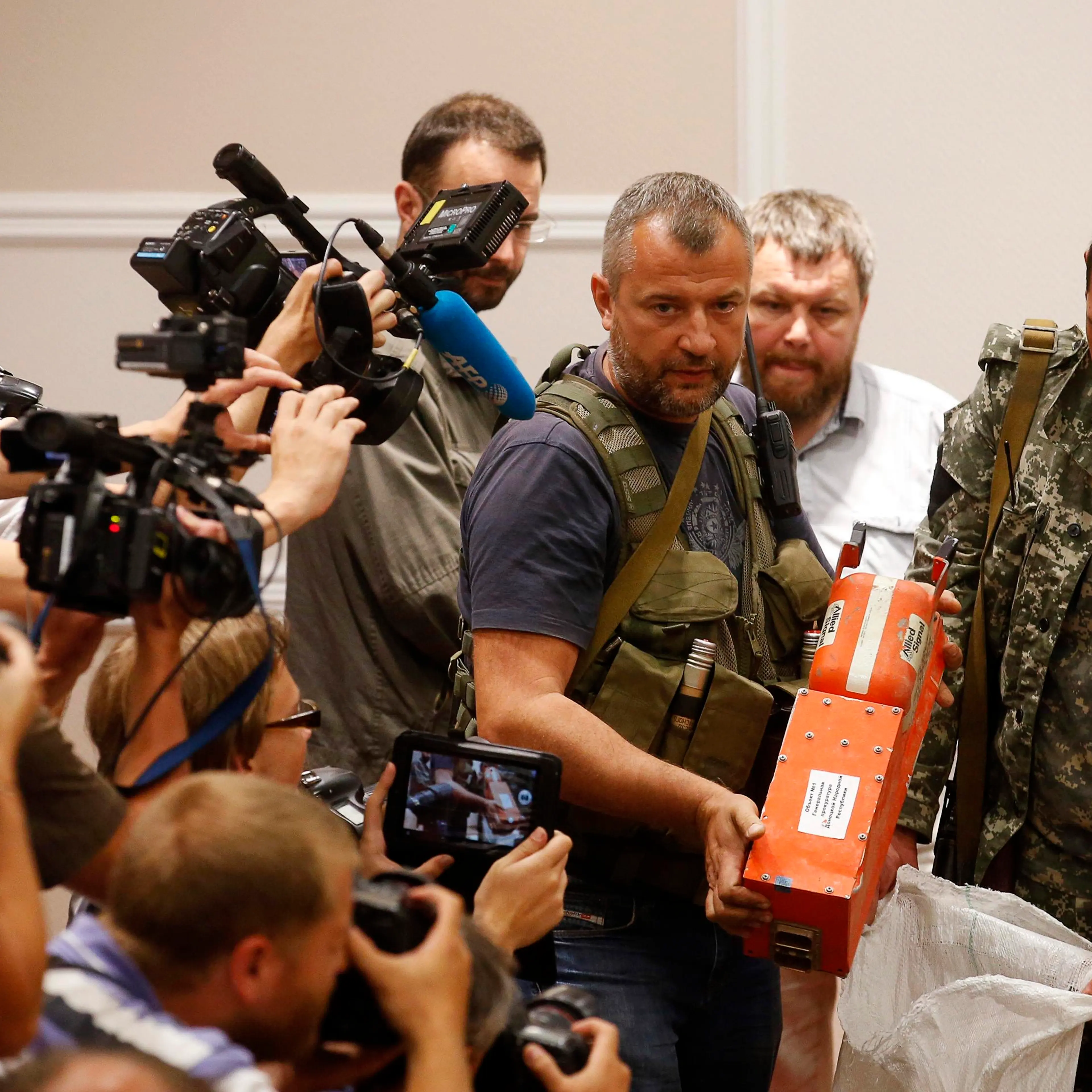 A pro-Russian separatist shows members of the media a black box belonging to Malaysia Airlines flight MH17, before its handover to Malaysian representatives, in Donetsk on July 22, 2014.