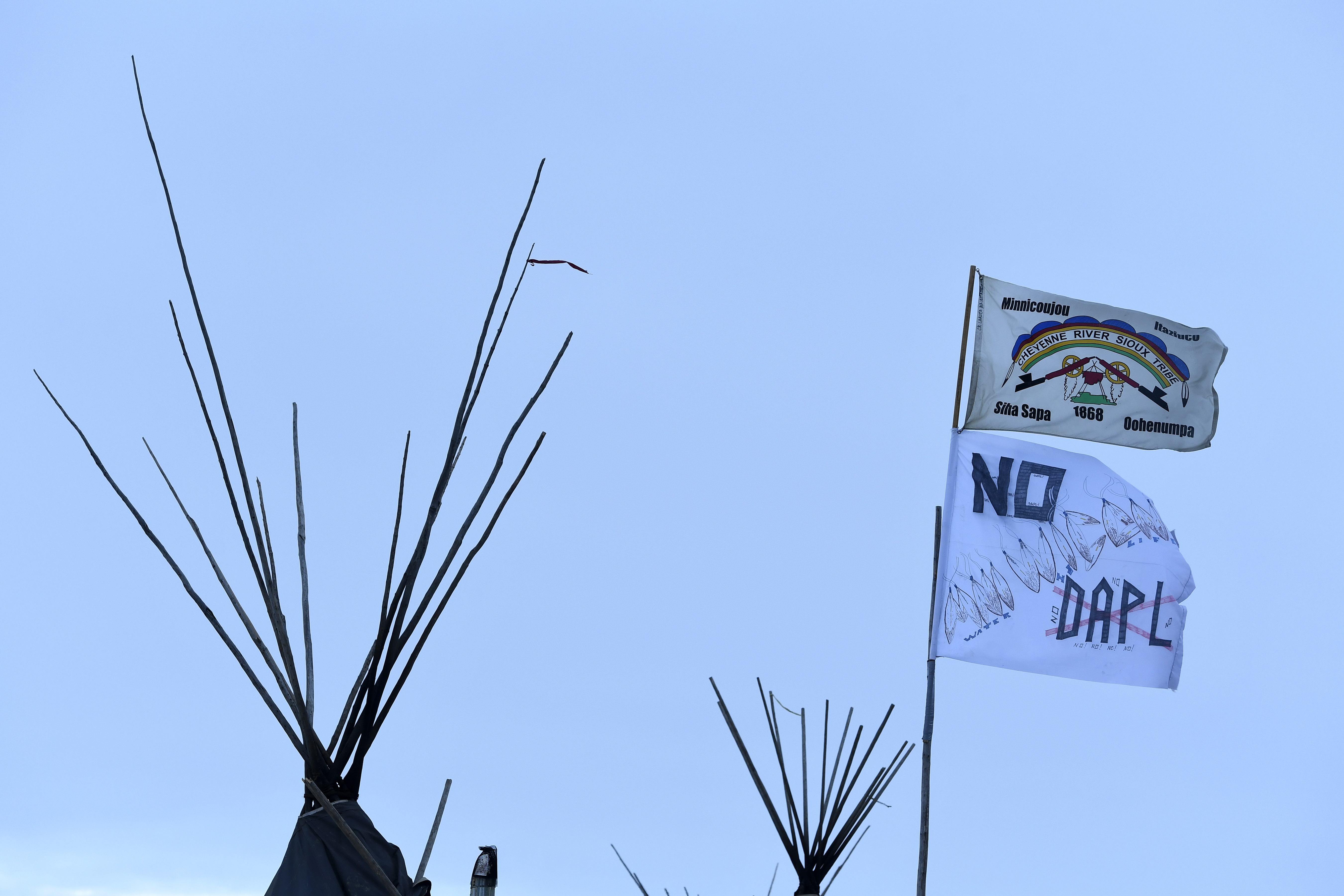 Flags fly in opposition to the Dakota Access Pipeline at the encampment at Oceti Sakowin camp on the Standing Rock Sioux Reservation on December 4, 2016 in Cannon Ball North Dakota, Colorado.