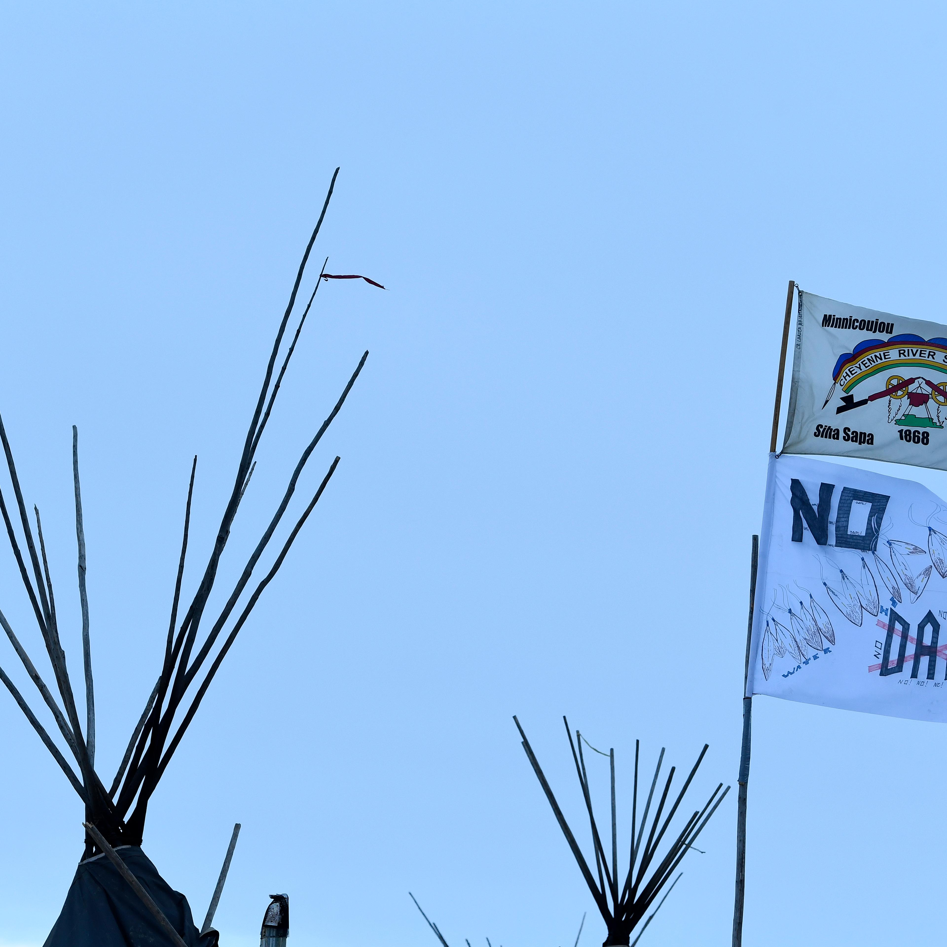 Flags fly in opposition to the Dakota Access Pipeline at the encampment at Oceti Sakowin camp on the Standing Rock Sioux Reservation on December 4, 2016 in Cannon Ball North Dakota, Colorado.