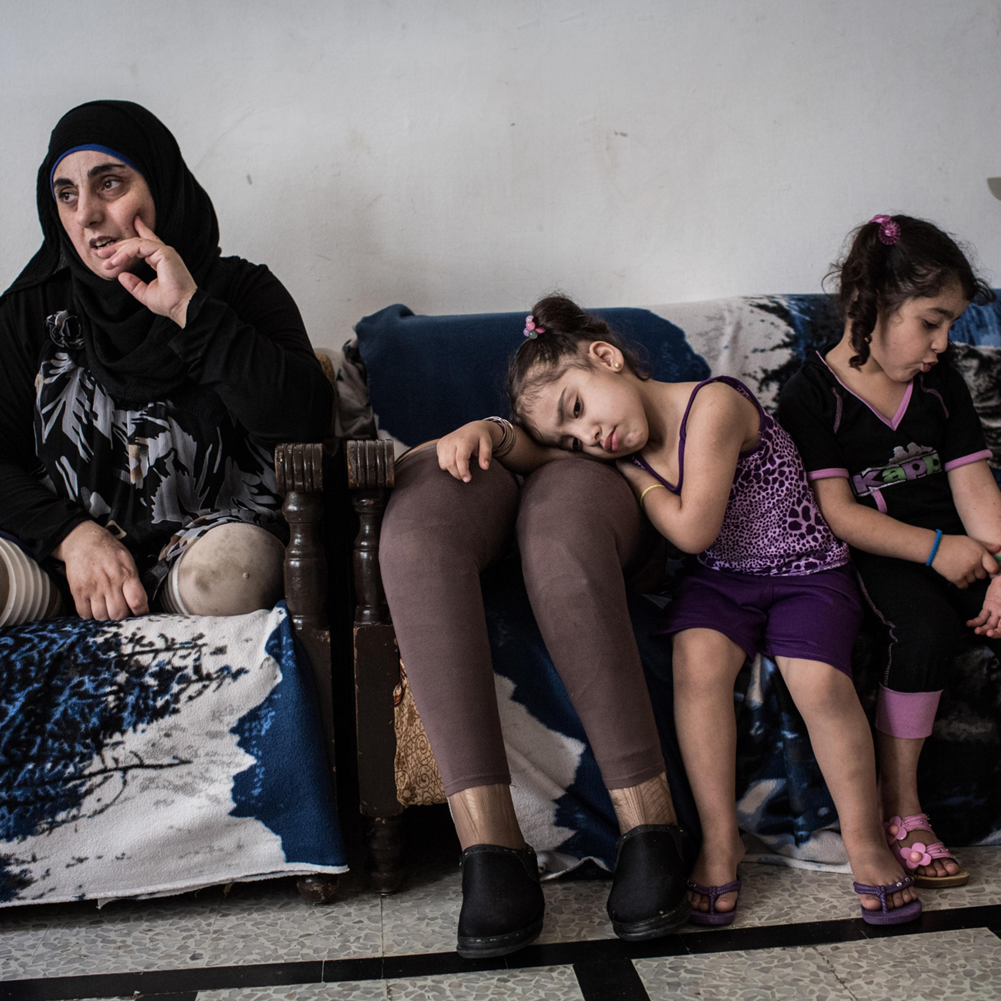 Hasna, pictured with her nieces, Aseel and Hadeel, 4, in their shared home in Tripoli, on June 11, 2014. In March 2012, Hasna, her husband and her two children were traveling on a motorcycle in Qusayr when a bomb fell nearby: “My daughter was sleeping i