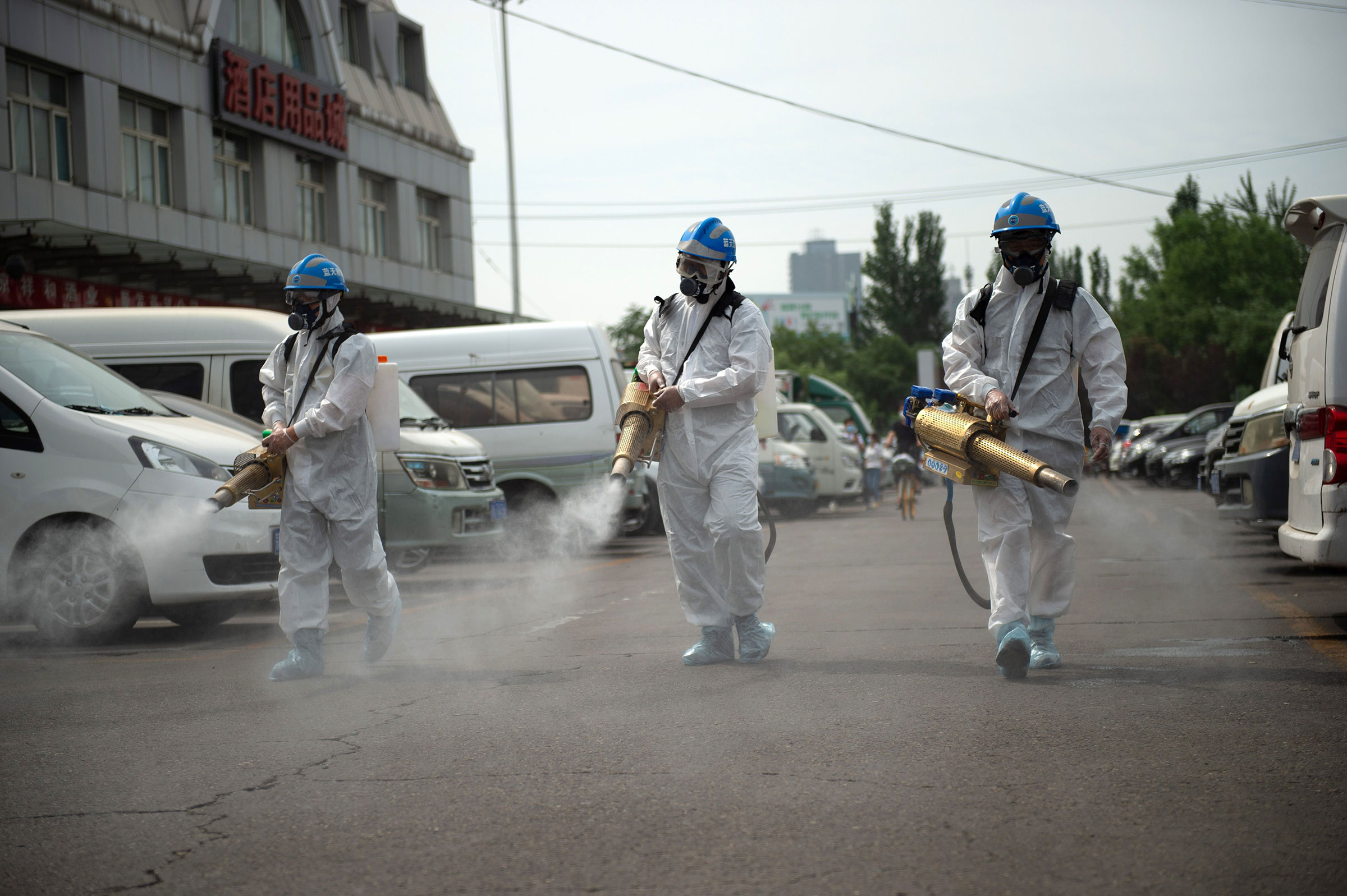 Members of the Beijing Blue Sky Rescue team conduct disinfection at the Yuegezhuang wholesale market in Beijing