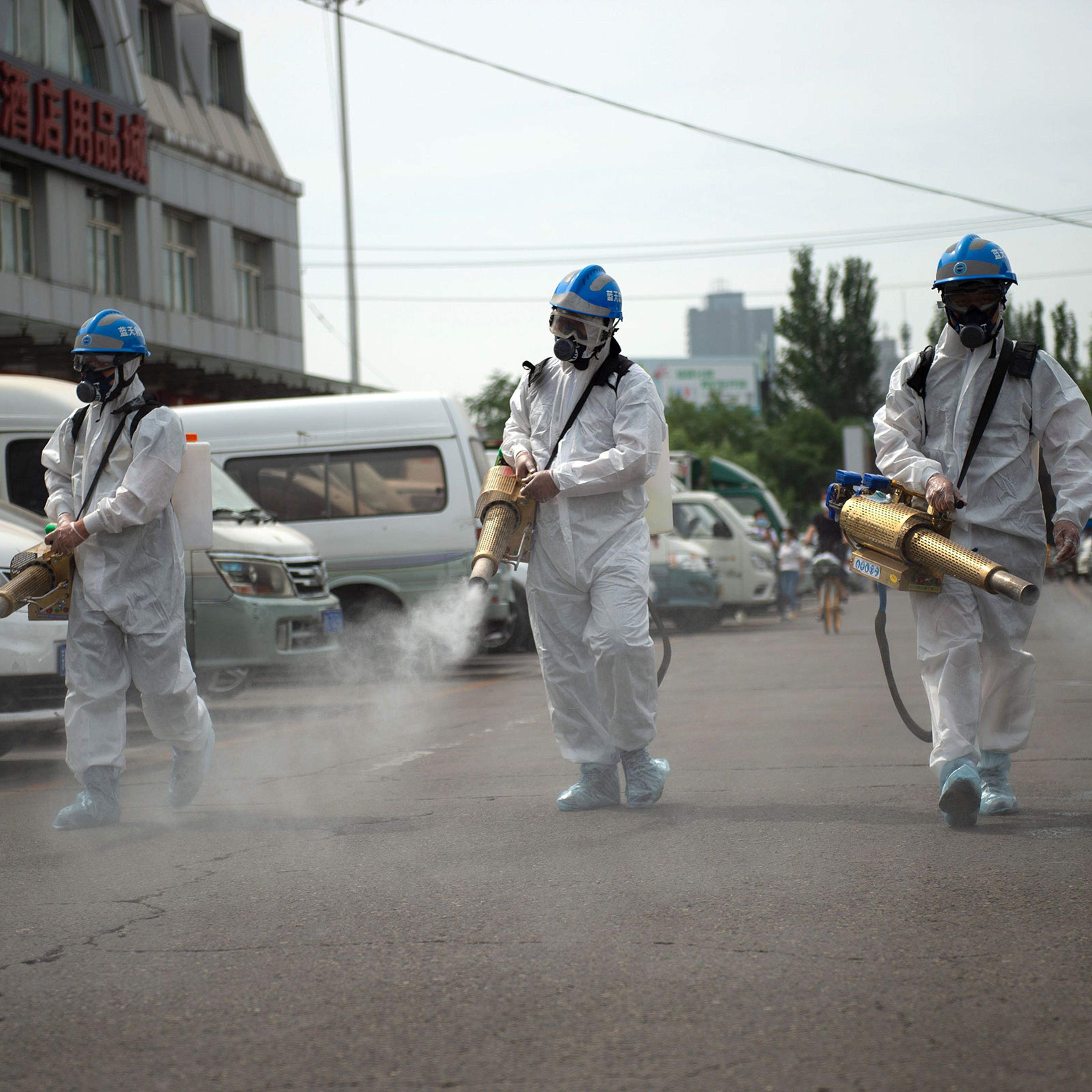 Members of the Beijing Blue Sky Rescue team conduct disinfection at the Yuegezhuang wholesale market in Beijing