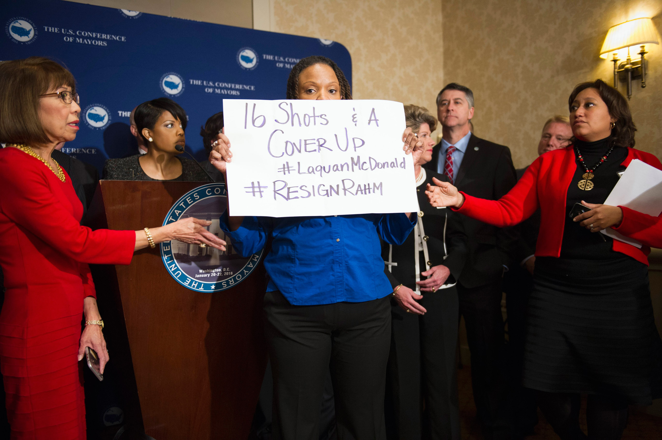 Burnsville, Minn. Mayor Elizabeth Kautz, Burnsville, left, tries to move Black Lives Matters demonstrator April Goggans, 36, of Washington, D.C., as she interrupts a news conference during the U..S. Conference of Mayors Winter Meeting in Washington, Wedn