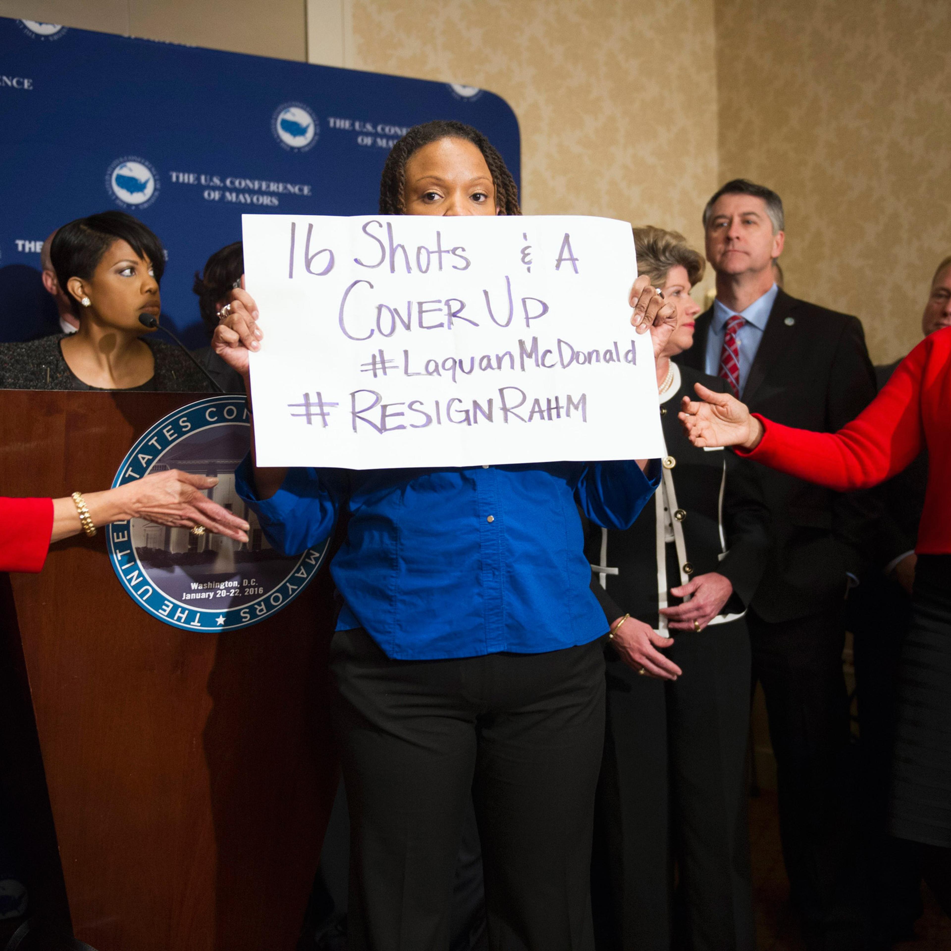Burnsville, Minn. Mayor Elizabeth Kautz, Burnsville, left, tries to move Black Lives Matters demonstrator April Goggans, 36, of Washington, D.C., as she interrupts a news conference during the U..S. Conference of Mayors Winter Meeting in Washington, Wedn