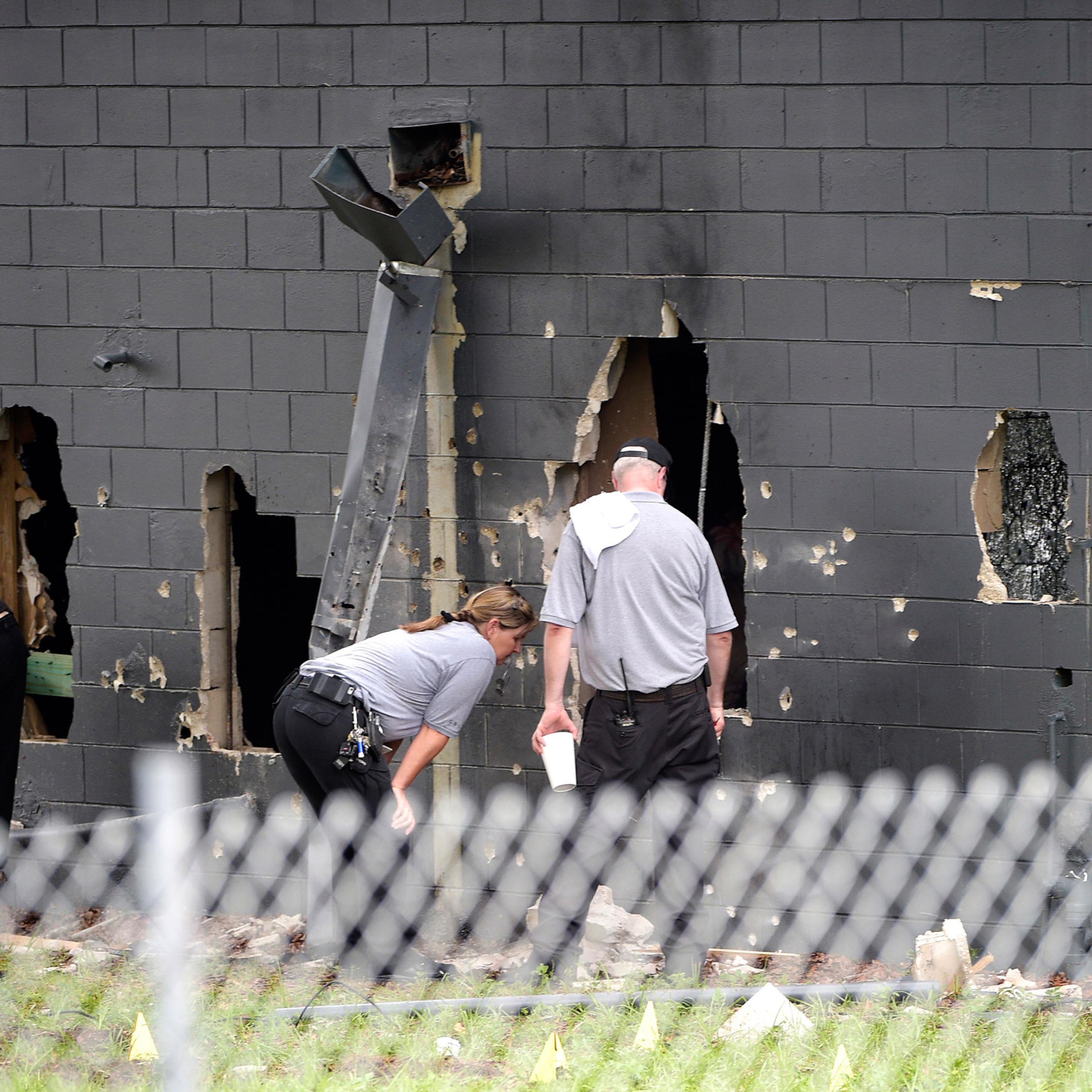 Police officials investigate the back of the Pulse nightclub after a shooting involving multiple fatalities at the nightclub in Orlando, Fla., Sunday, June 12, 2016. (AP Photo/Phelan M. Ebenhack)