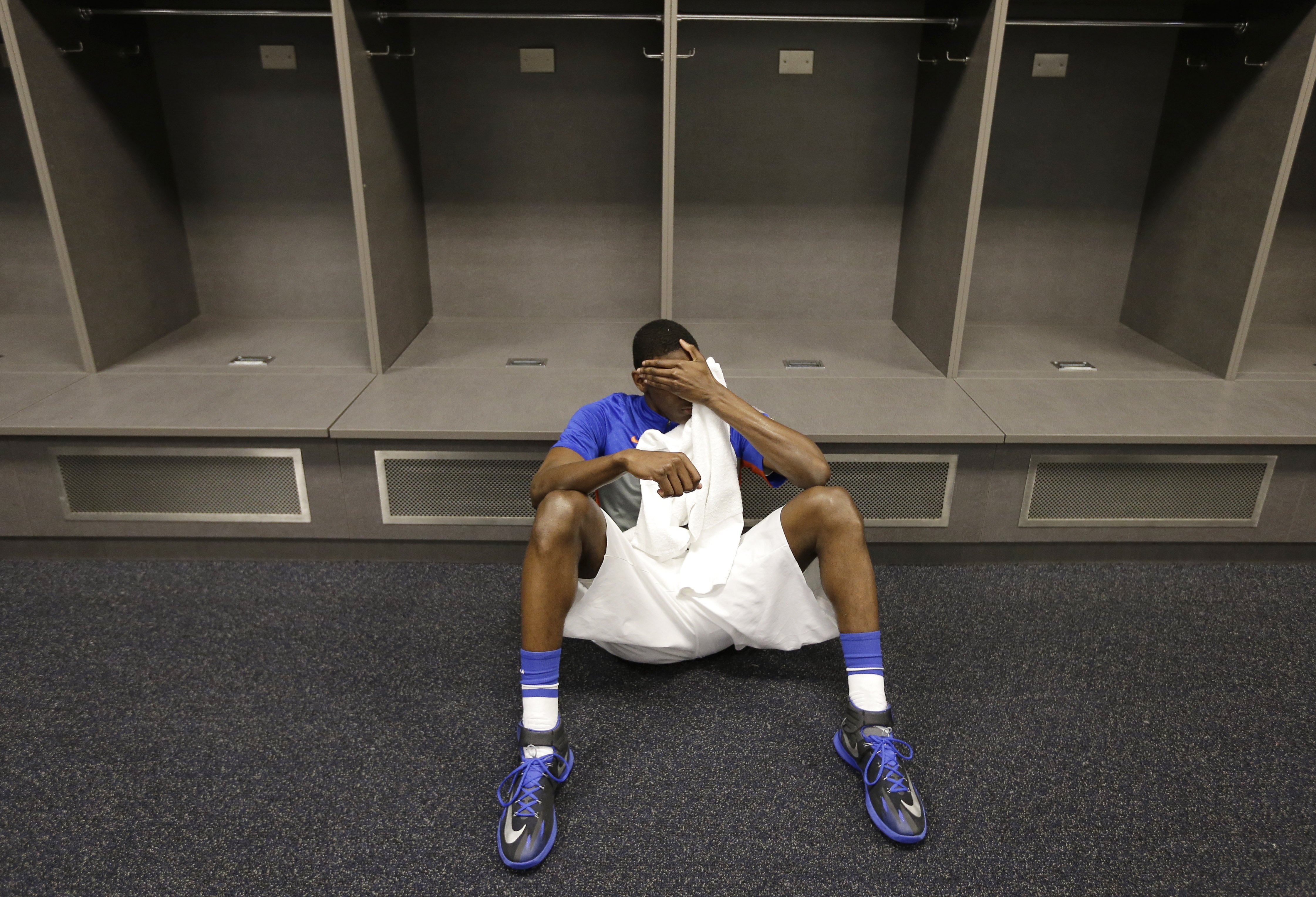 Florida forward Dorian Finney-Smith rests on the floor of the locker room after losing to Connecticut in the NCAA Tournament Final Four, April 5, 2014, in Arlington, Texas.  Connecticut won 63-53.