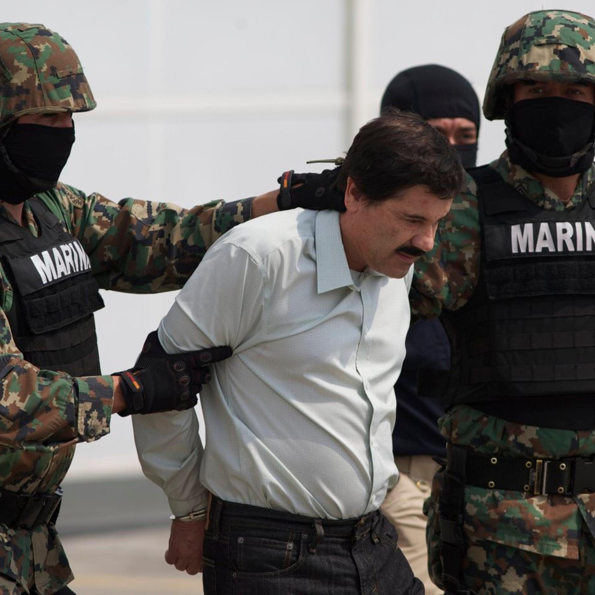 Joaquin "El Chapo" Guzman is escorted to a helicopter in handcuffs by Mexican marines at a navy hanger in Mexico City, on Feb. 22, 2014.