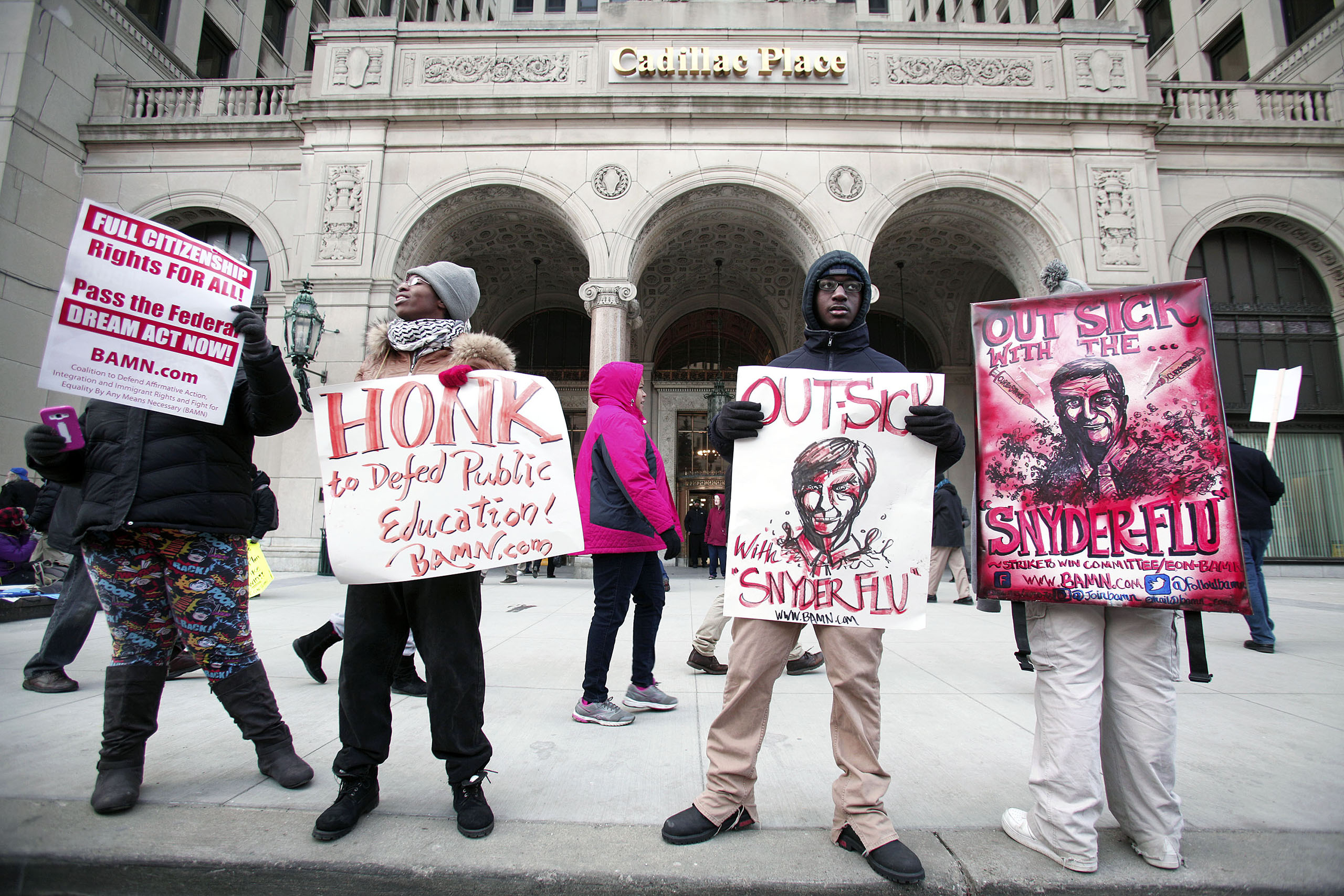 Demonstrators protest outside a hearing, to decide whether to and a "sick-out" by public school teachers and organizers, at the State of Michigan Building in Detroit, Jan. 25, 2016.