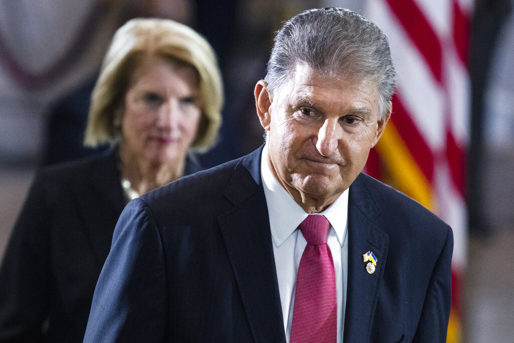 Sen. Joe Manchin, D-W.Va., and Sen. Shelley Moore Capito, R-W.Va., pay their respects as the flag-draped casket bearing the remains of Hershel W. "Woody" Williams, lies in honor in the U.S. Capitol, Thursday, July 14, 2022 in Washington. 