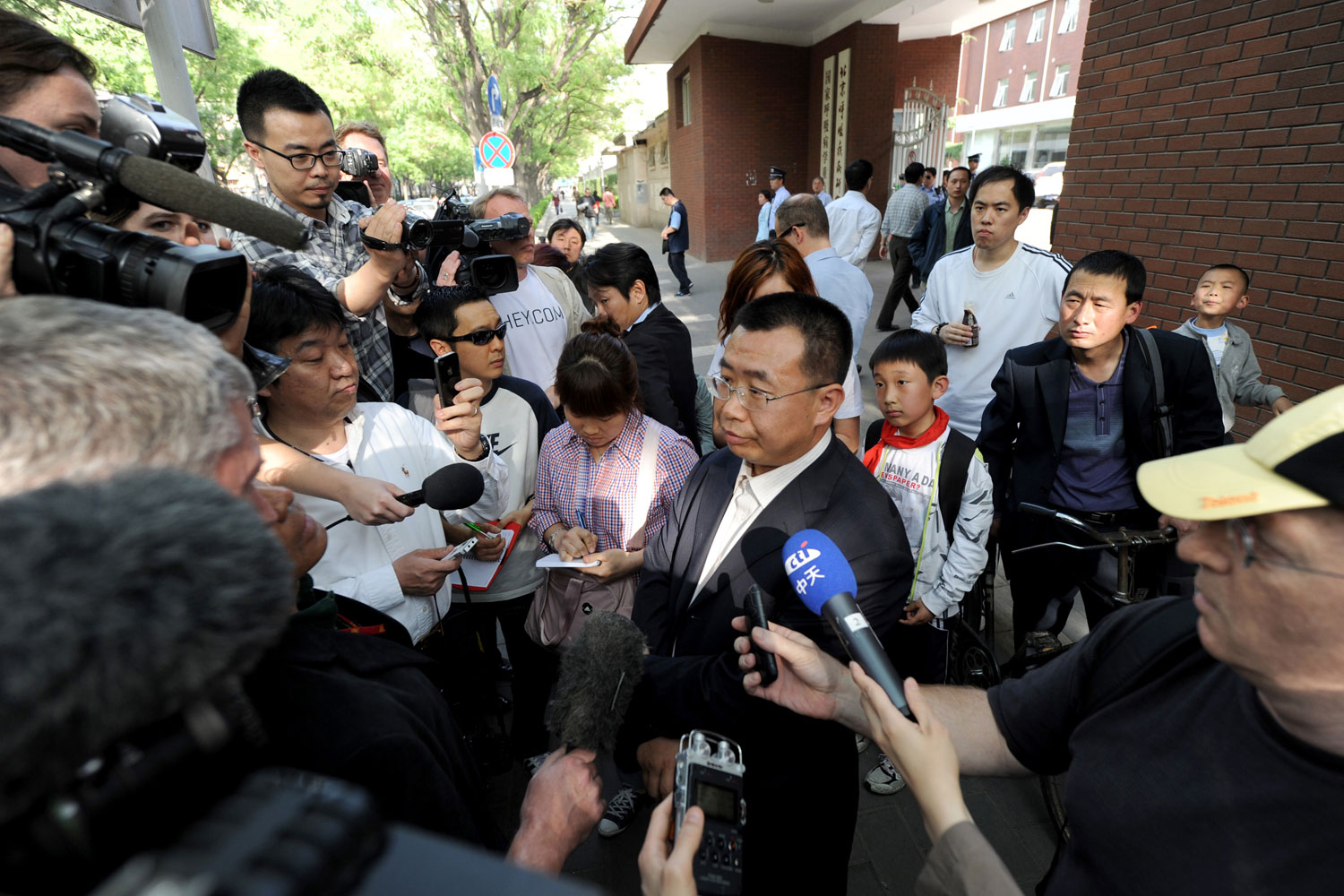 Journalists interview Chinese rights lawyer Jiang Tianyong at a gate of the Chaoyang hospital in Beijing in Beijing on May 2, 2012.