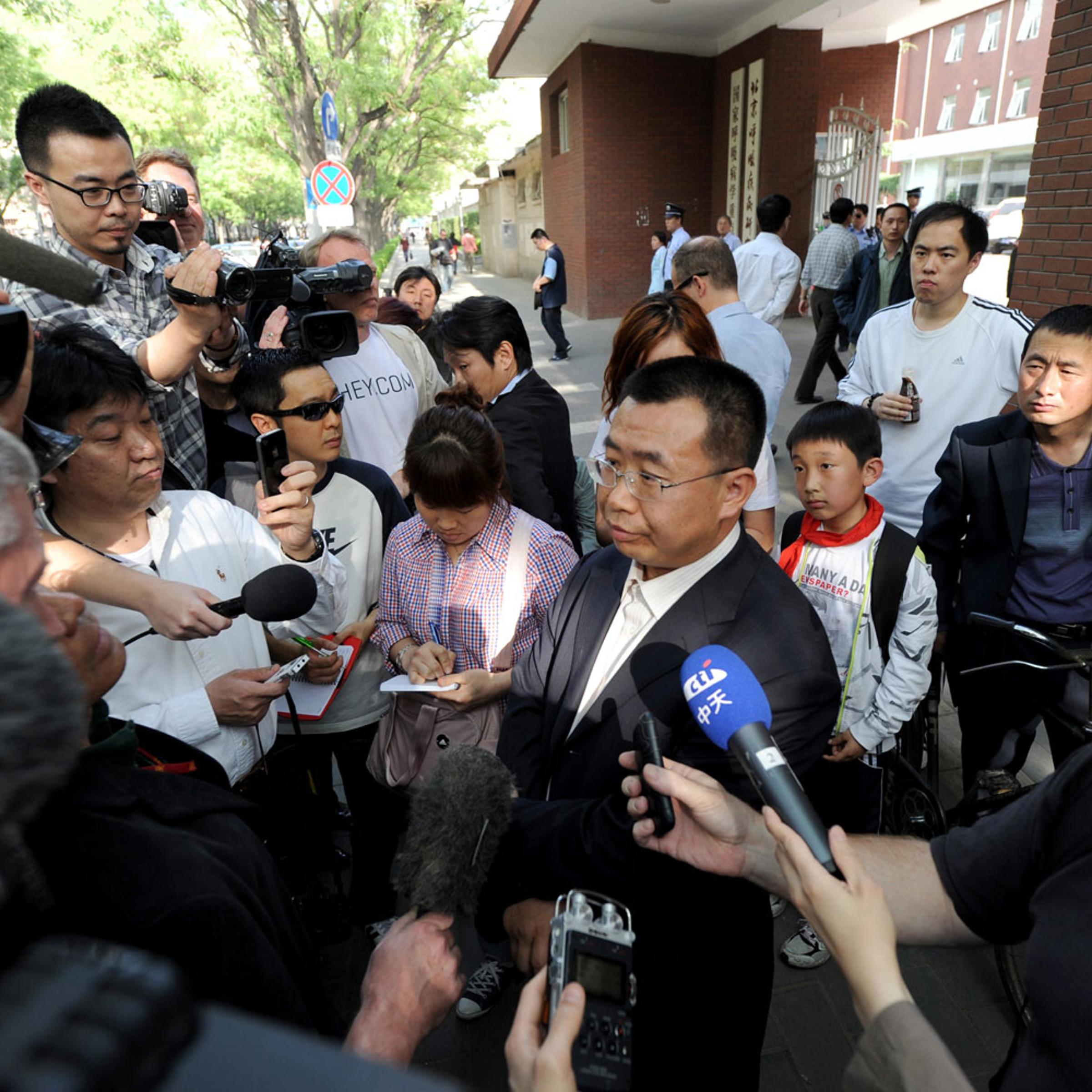 Journalists interview Chinese rights lawyer Jiang Tianyong at a gate of the Chaoyang hospital in Beijing in Beijing on May 2, 2012.