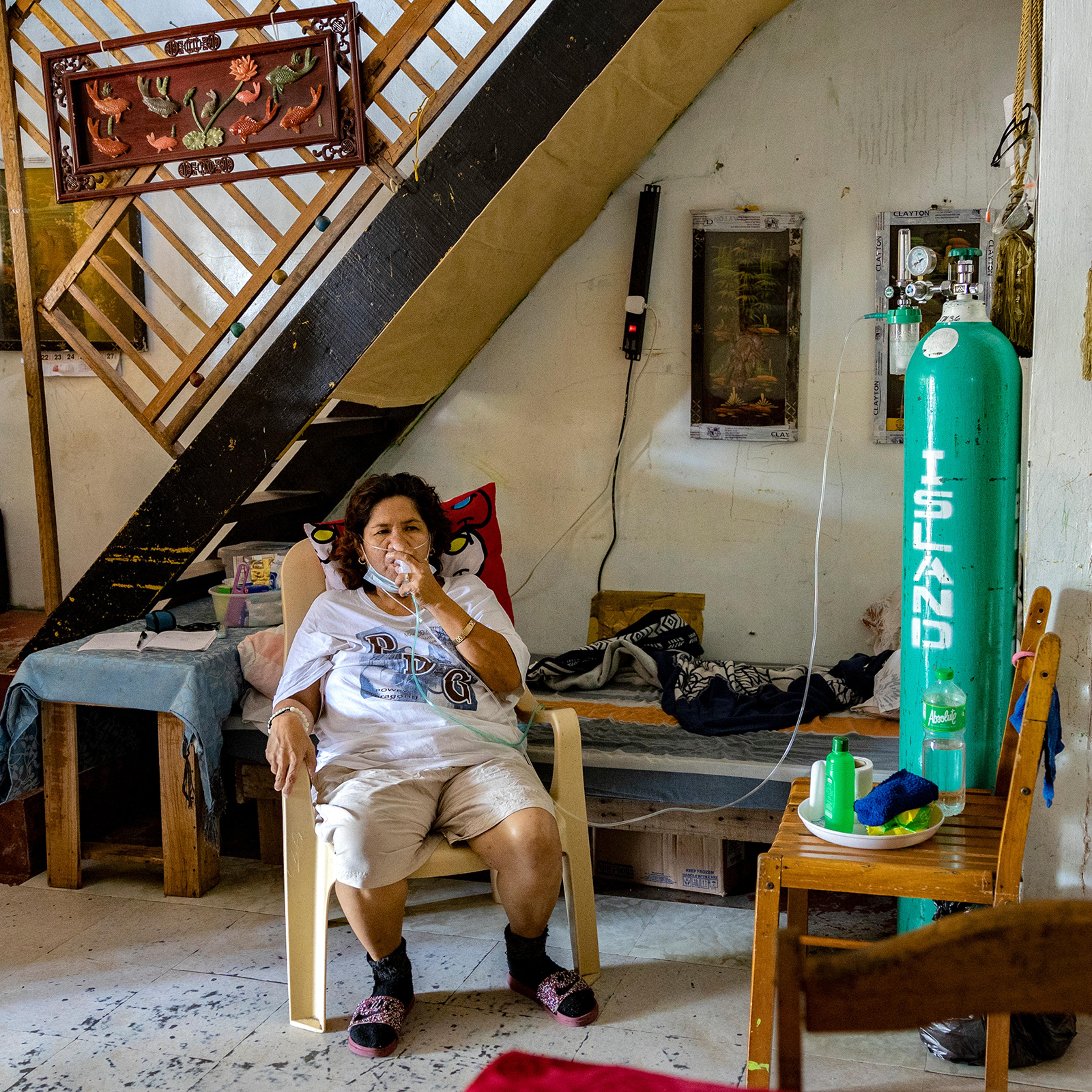 Violeta Bahit, who has COVID-19, breathes with the assistance of an oxygen tank in her home in Lipa, in the province of Batangas, Philippines, on April 9, 2021.