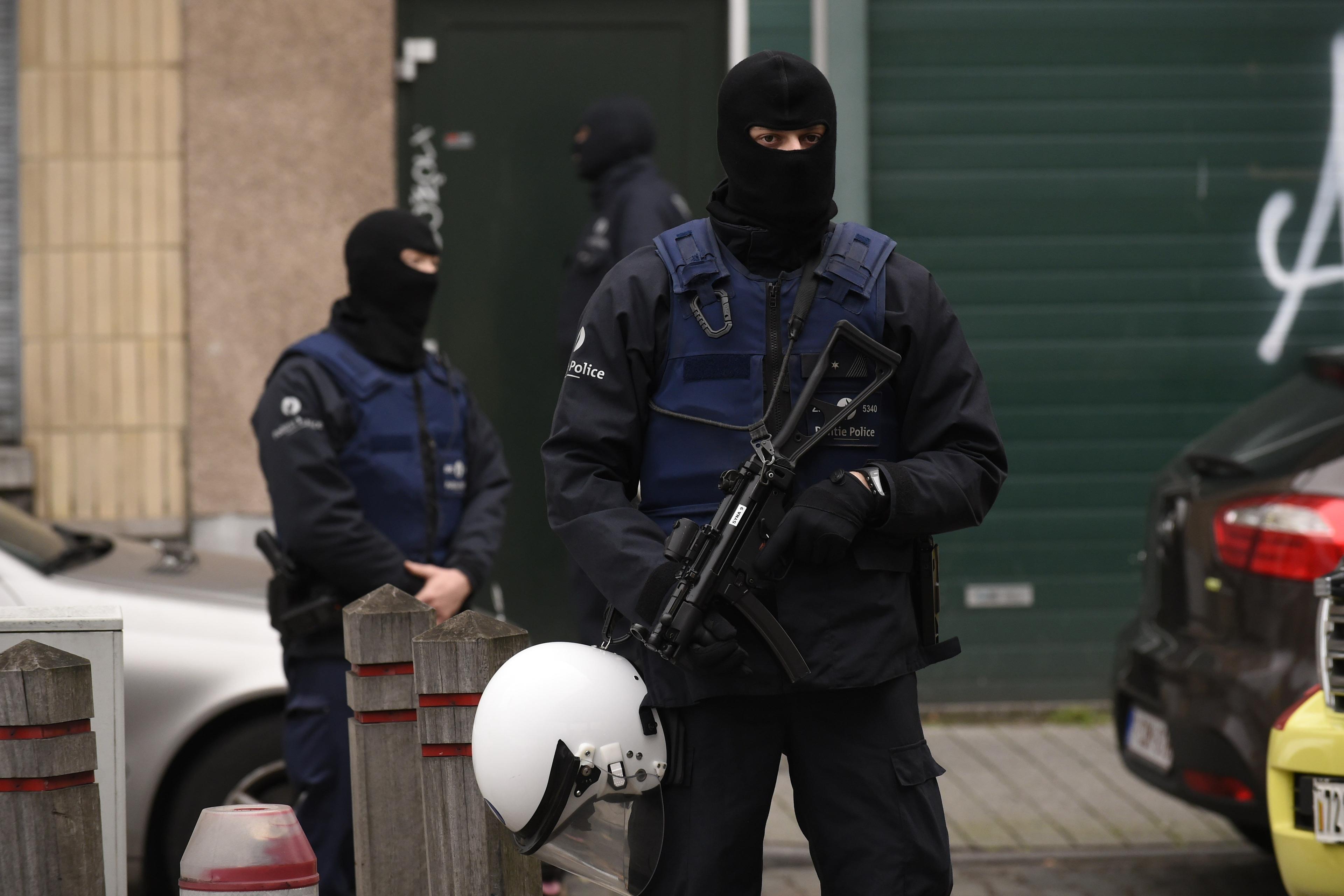 Police officers stand guard as an operation takes place in the Molenbeek district of Brussels on Nov. 16, 2015.