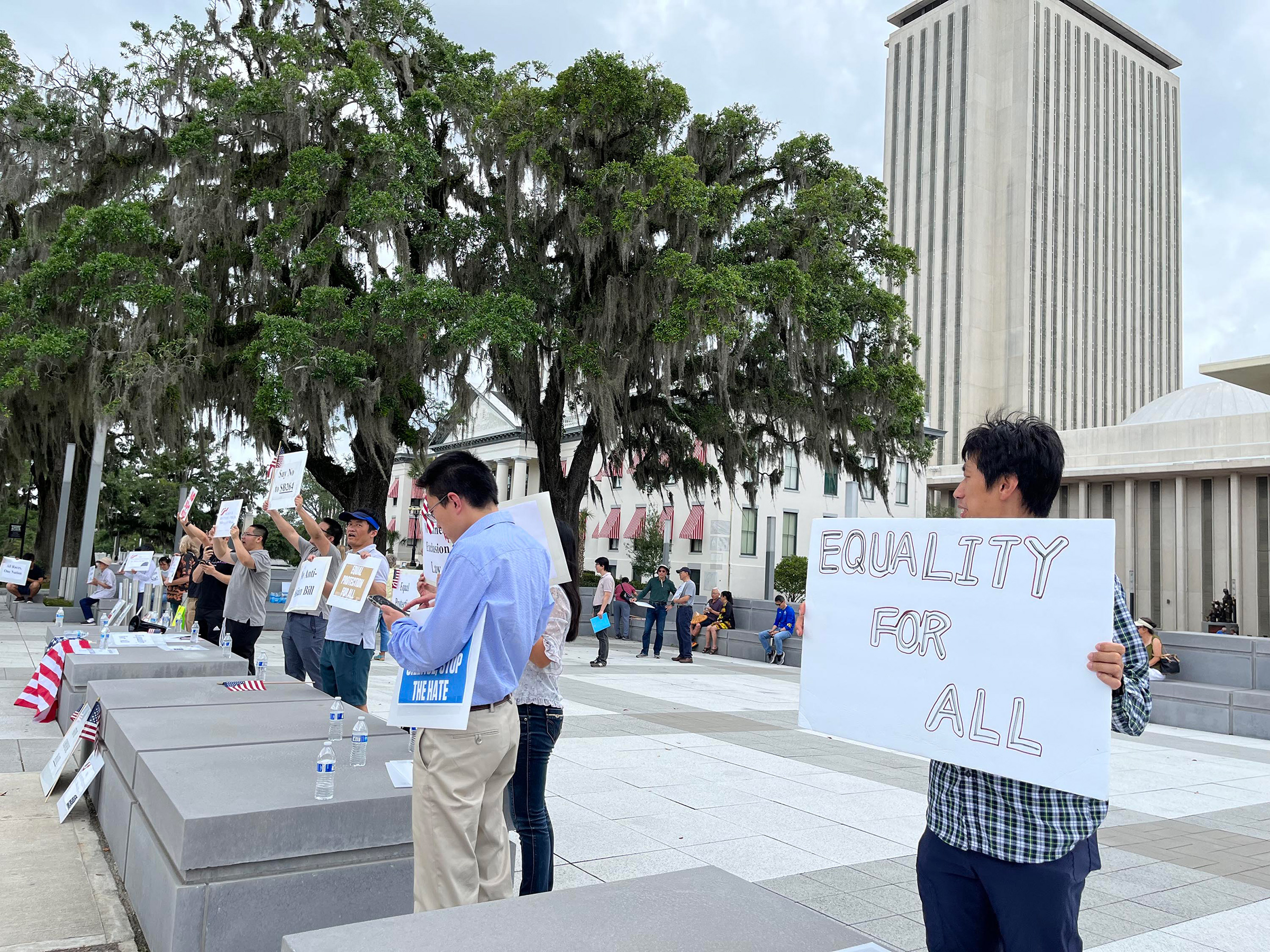 Protesters stand outside Florida's Capitol on April 29, in opposition to a bill that would ban Chinese people who are not U.S. citizens or permanent residents from owning any land or property in the state. 