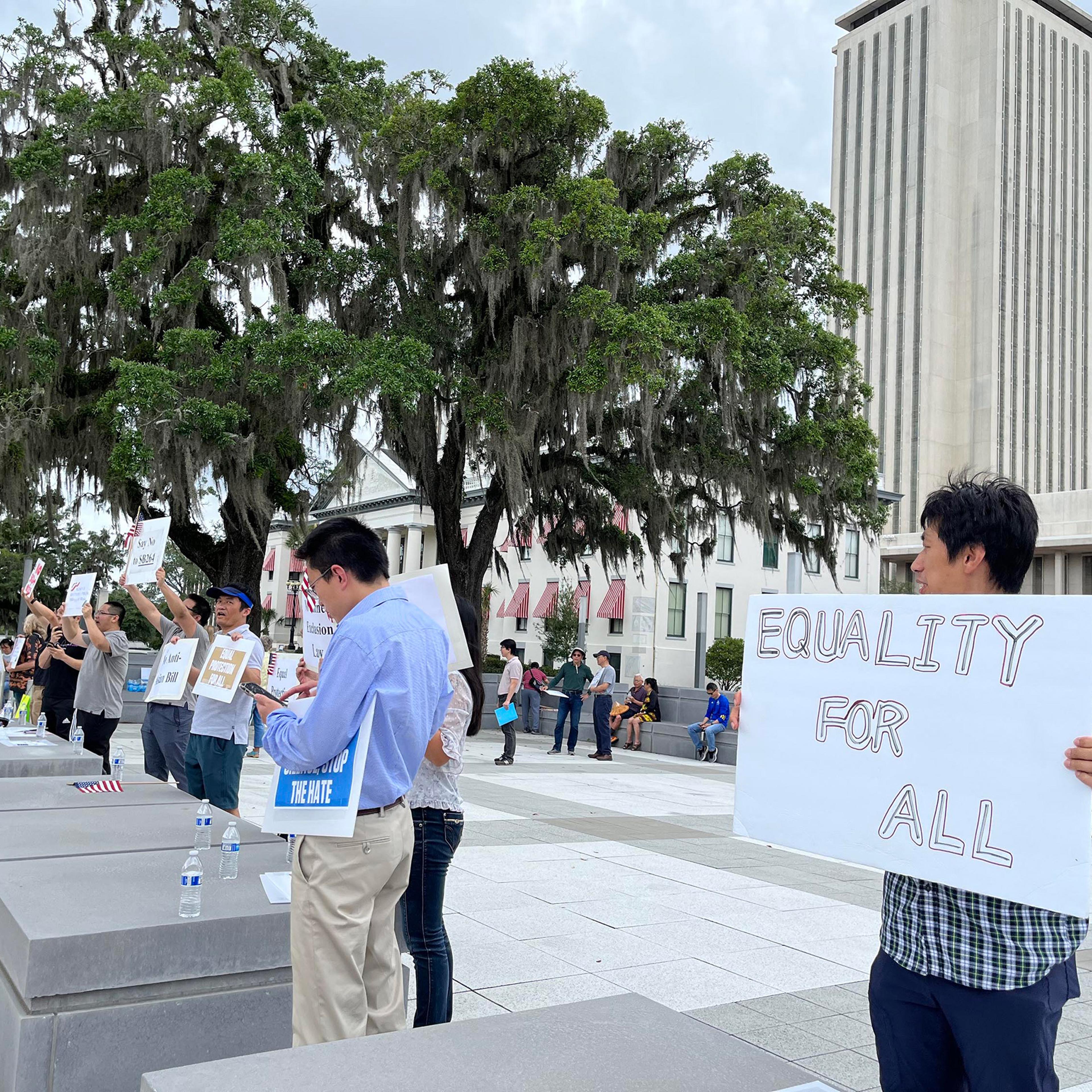 Protesters stand outside Florida's Capitol on April 29, in opposition to a bill that would ban Chinese people who are not U.S. citizens or permanent residents from owning any land or property in the state.