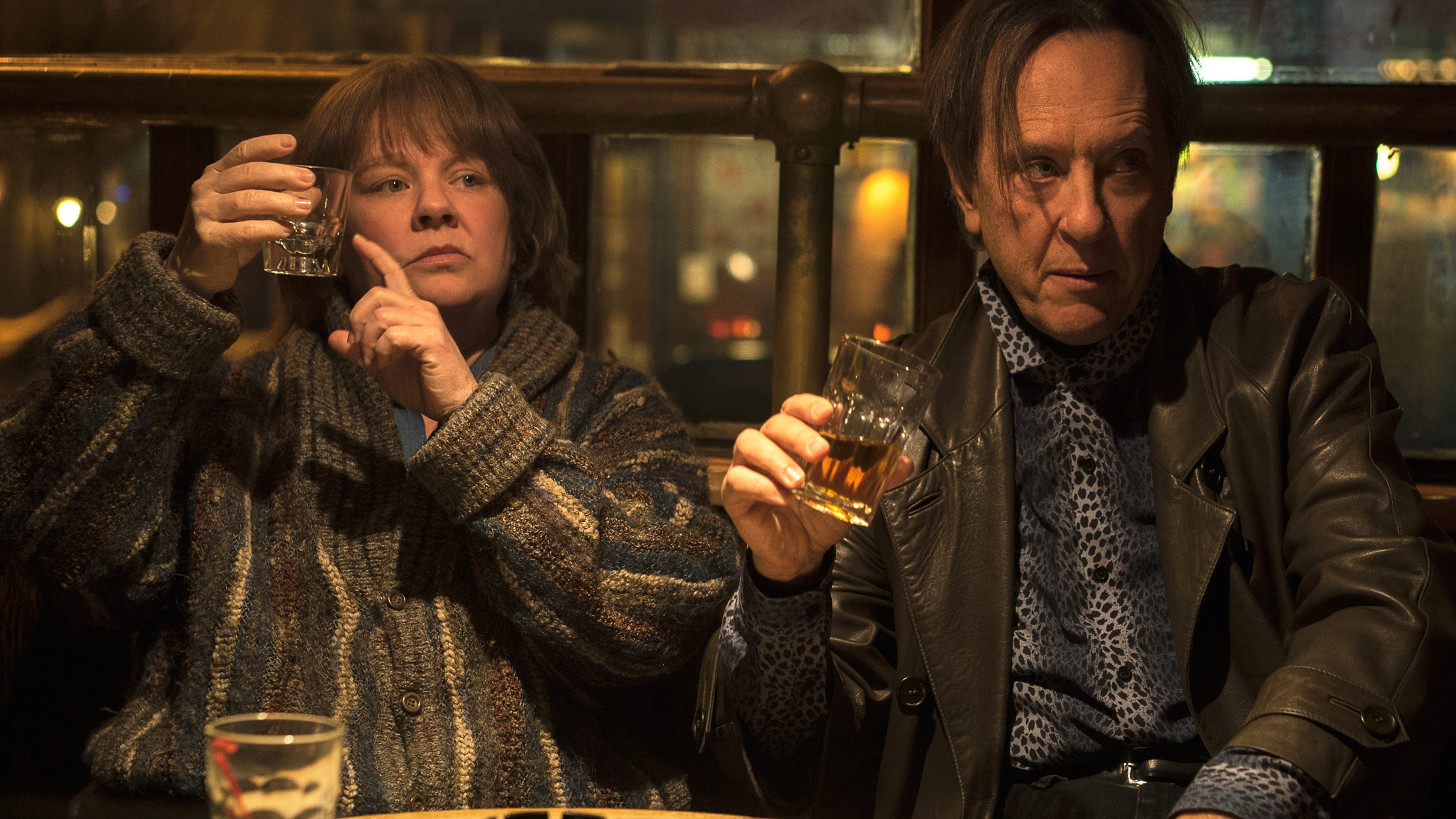 (McCarthy) and Jack (Grant) bond over a stiff drink—or 10