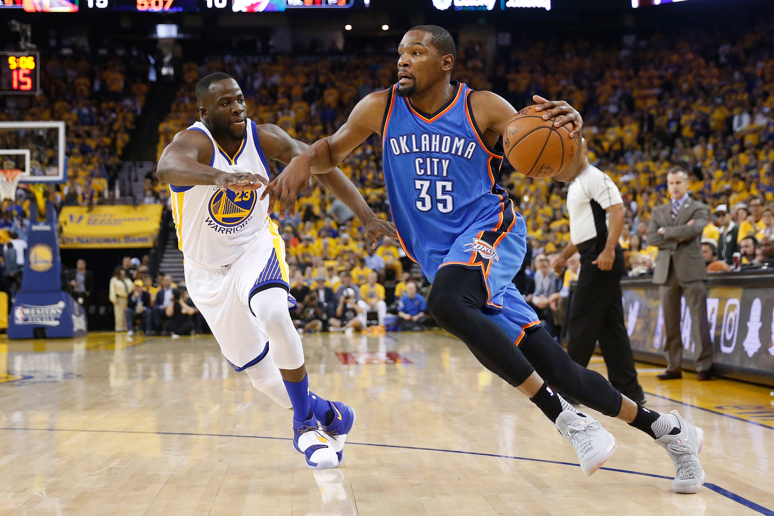 Kevin Durant drives with the ball against Draymond Green during Game Five of the Western Conference Finals during the 2016 NBA Playoffs in Oakland, Calif., on May 26, 2016.