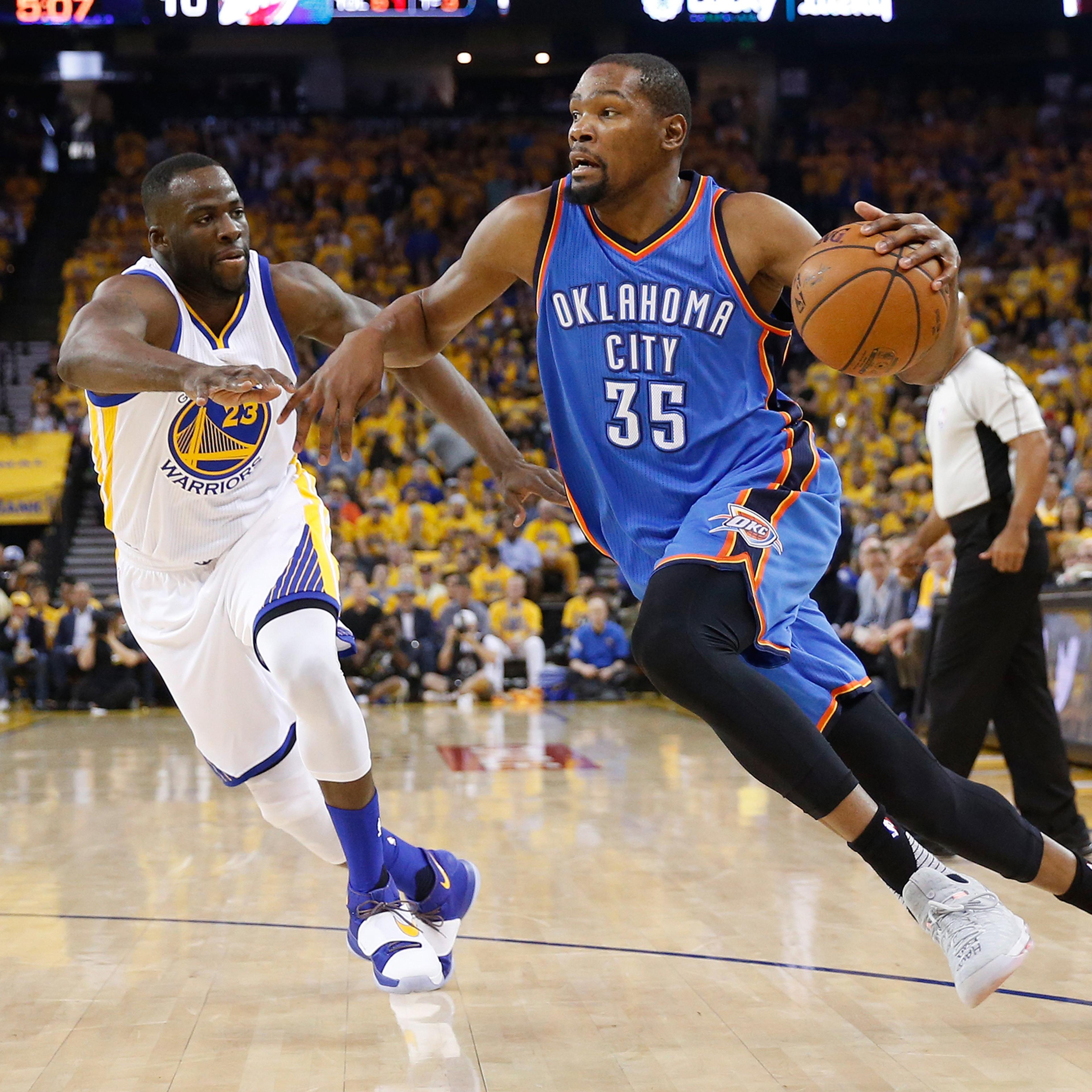 Kevin Durant drives with the ball against Draymond Green during Game Five of the Western Conference Finals during the 2016 NBA Playoffs in Oakland, Calif., on May 26, 2016.
