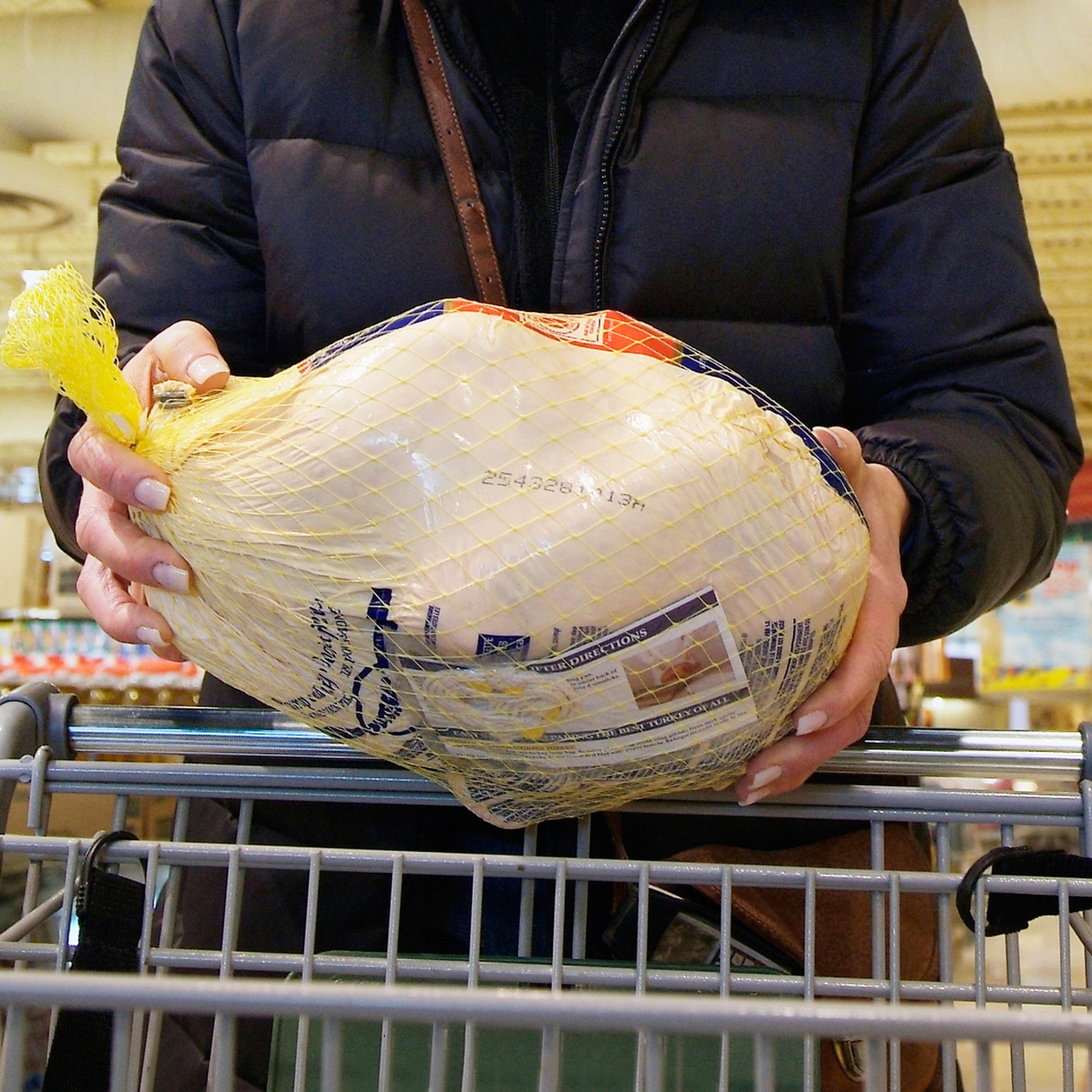 woman holding turkey in grocery store