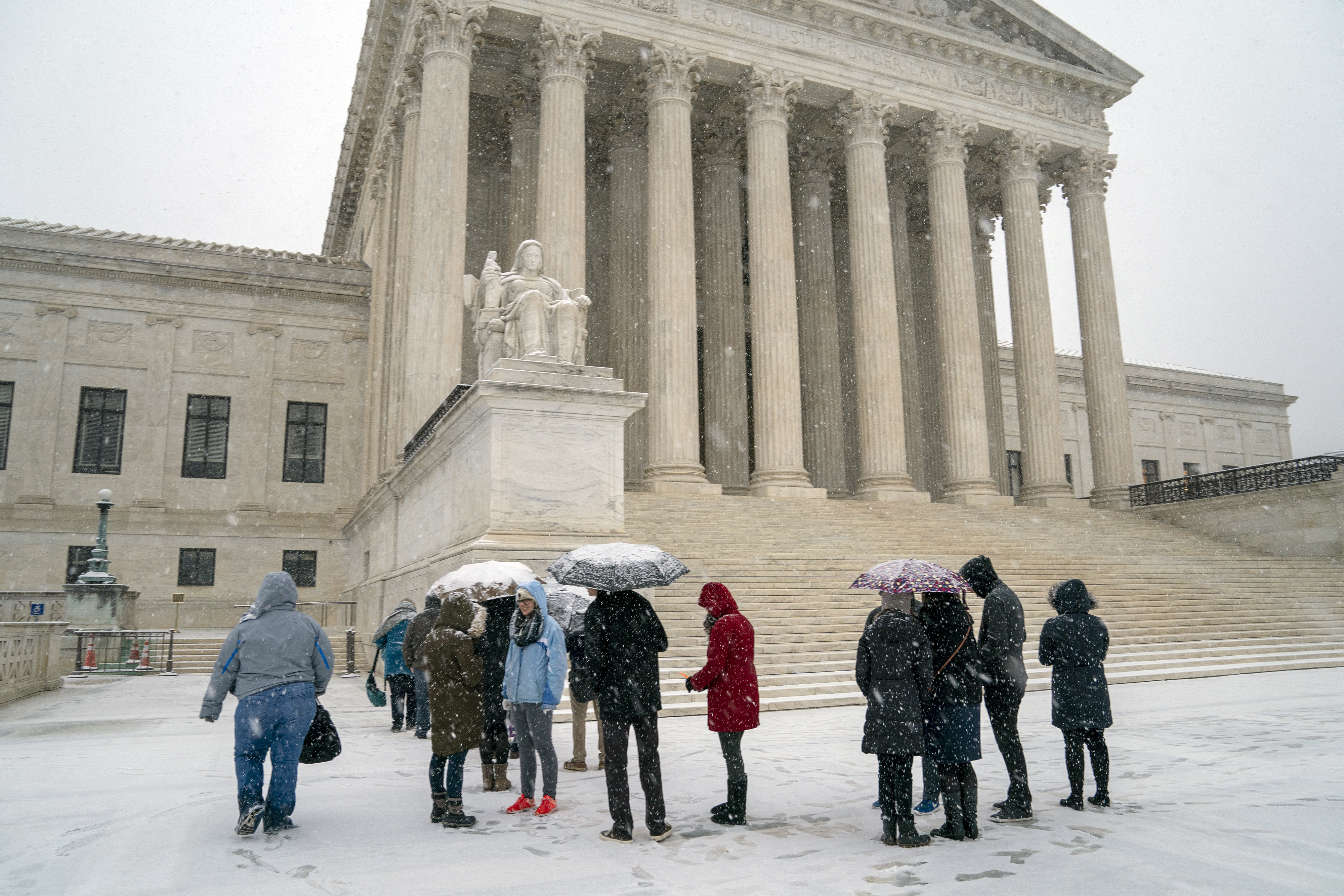 Visitors wait to enter the Supreme Court as a winter snow storm hits the nation's capital