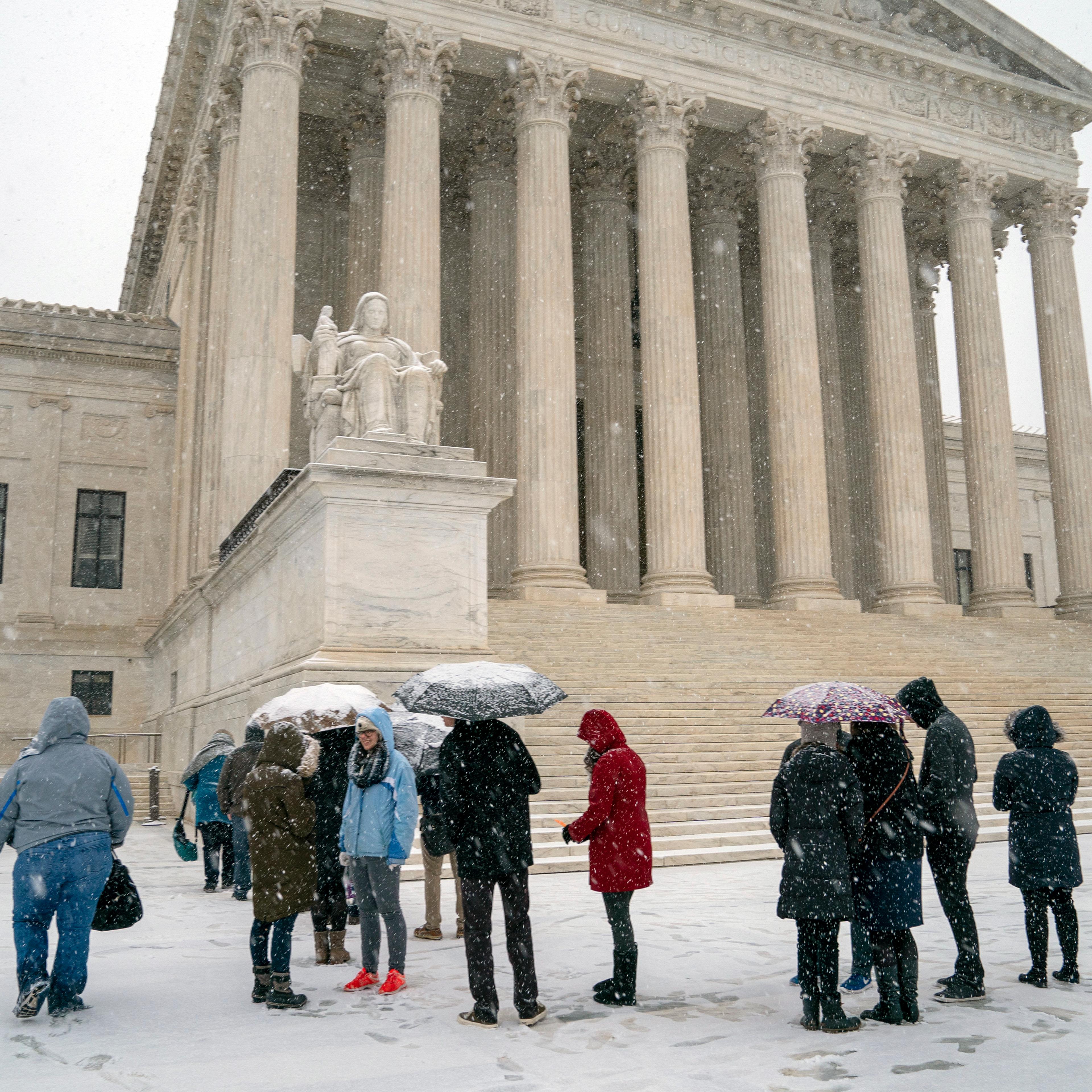 Visitors wait to enter the Supreme Court as a winter snow storm hits the nation's capital