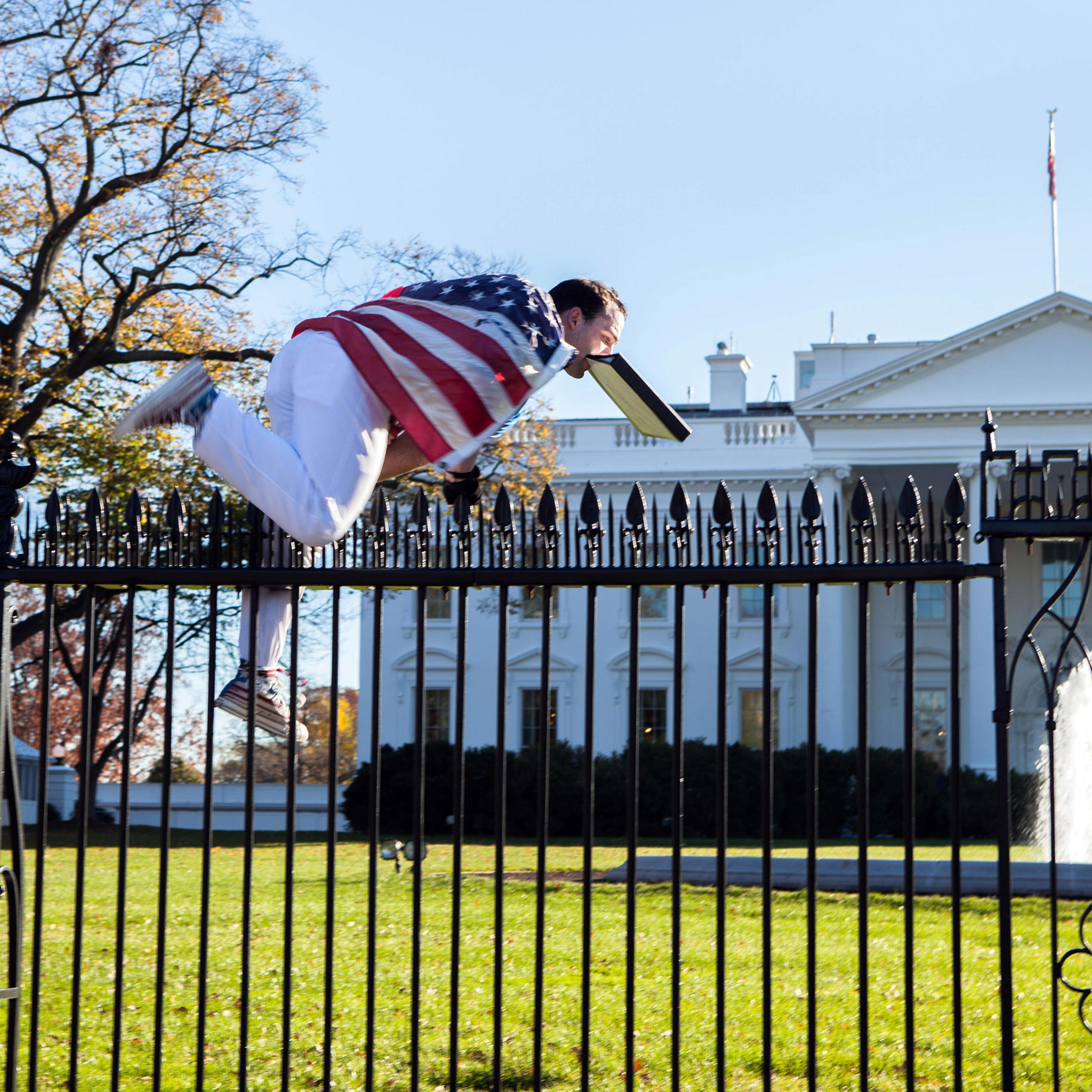 In this photo provided by Vanessa Pena, a man jumps a fence at the White House on Thursday, Nov. 26, 2015, in Washington. The man was immediately apprehended and taken into custody pending criminal charges, the Secret Service said. President Barack Obama