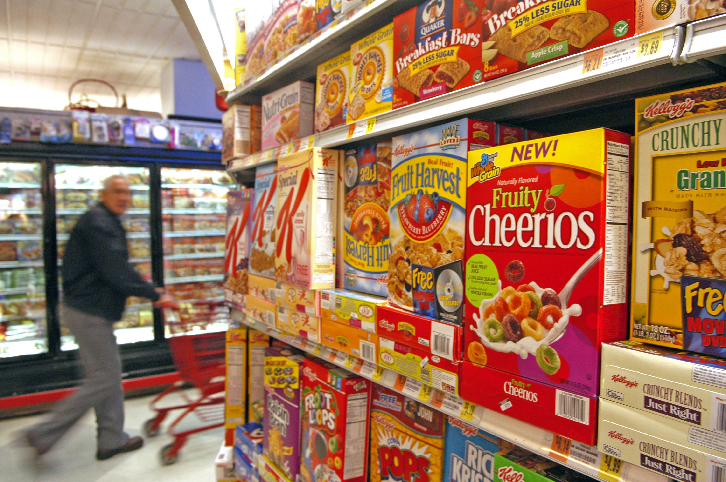A man pushes his shopping cart past the cereal aisle where G