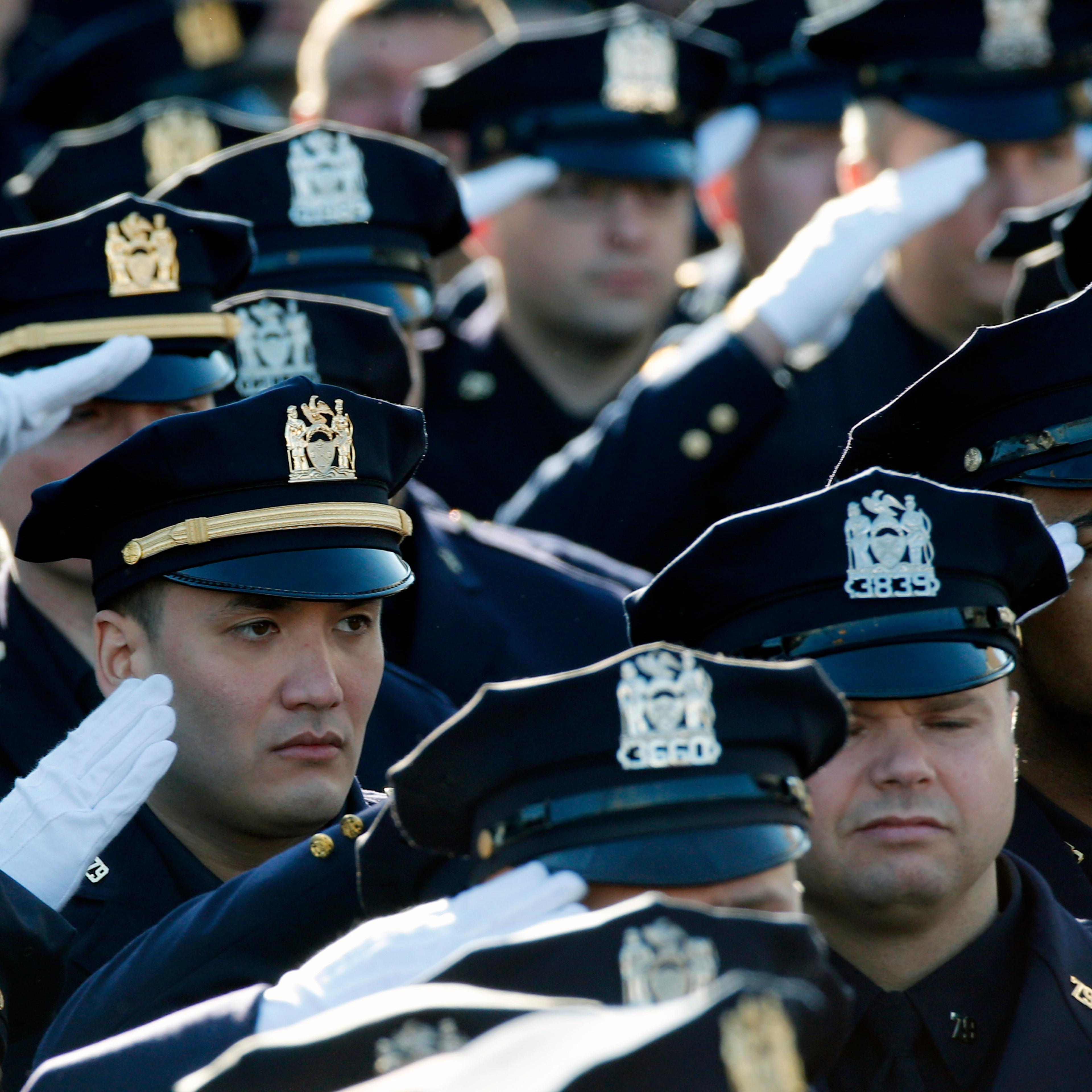 Police salute during the playing of the U.S. National Anthem outside the Christ Tabernacle Church at the start of the funeral service for slain NYPD officer Ramos in the Queens borough of New York