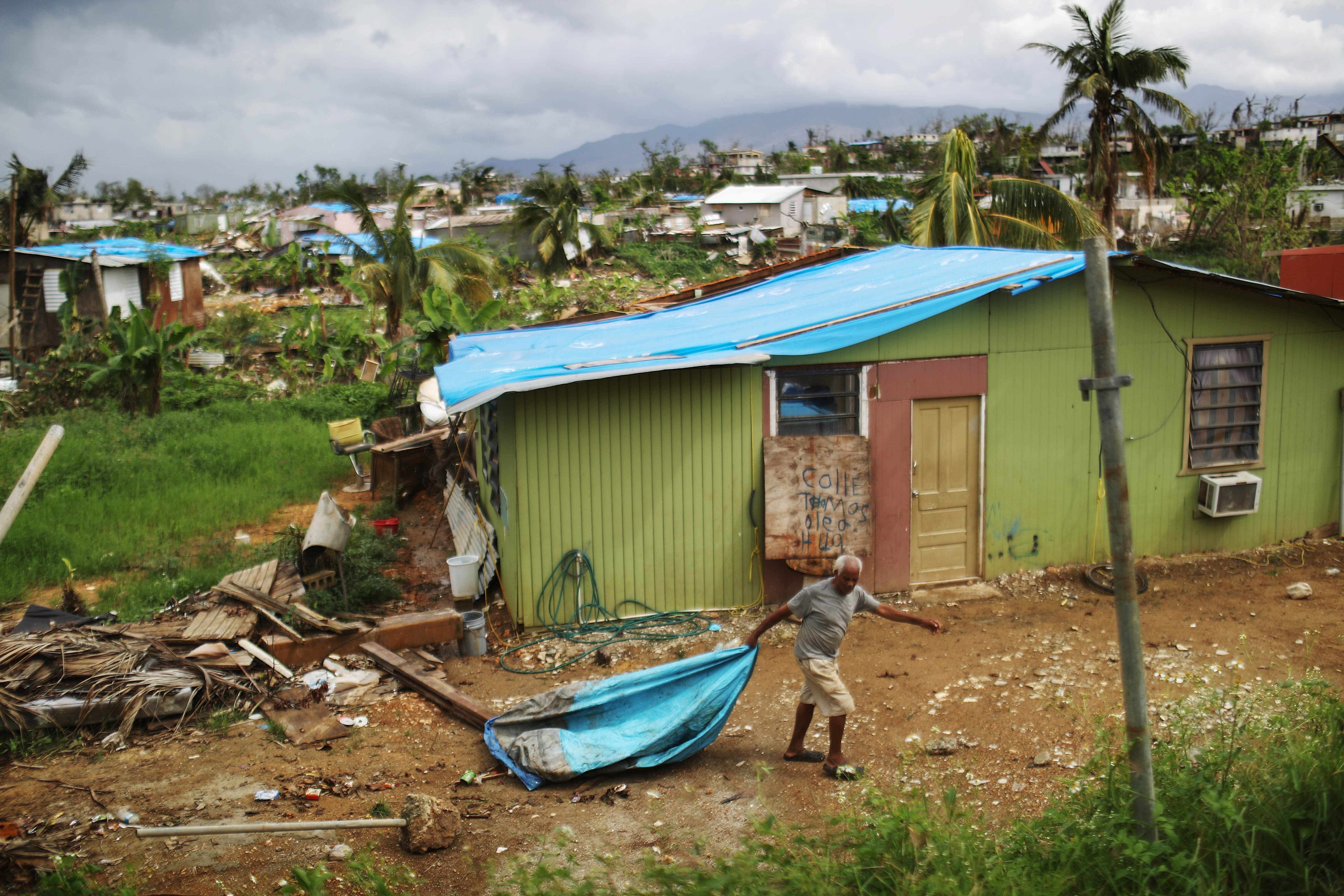 resident cleans debris near his damaged home puerto rico