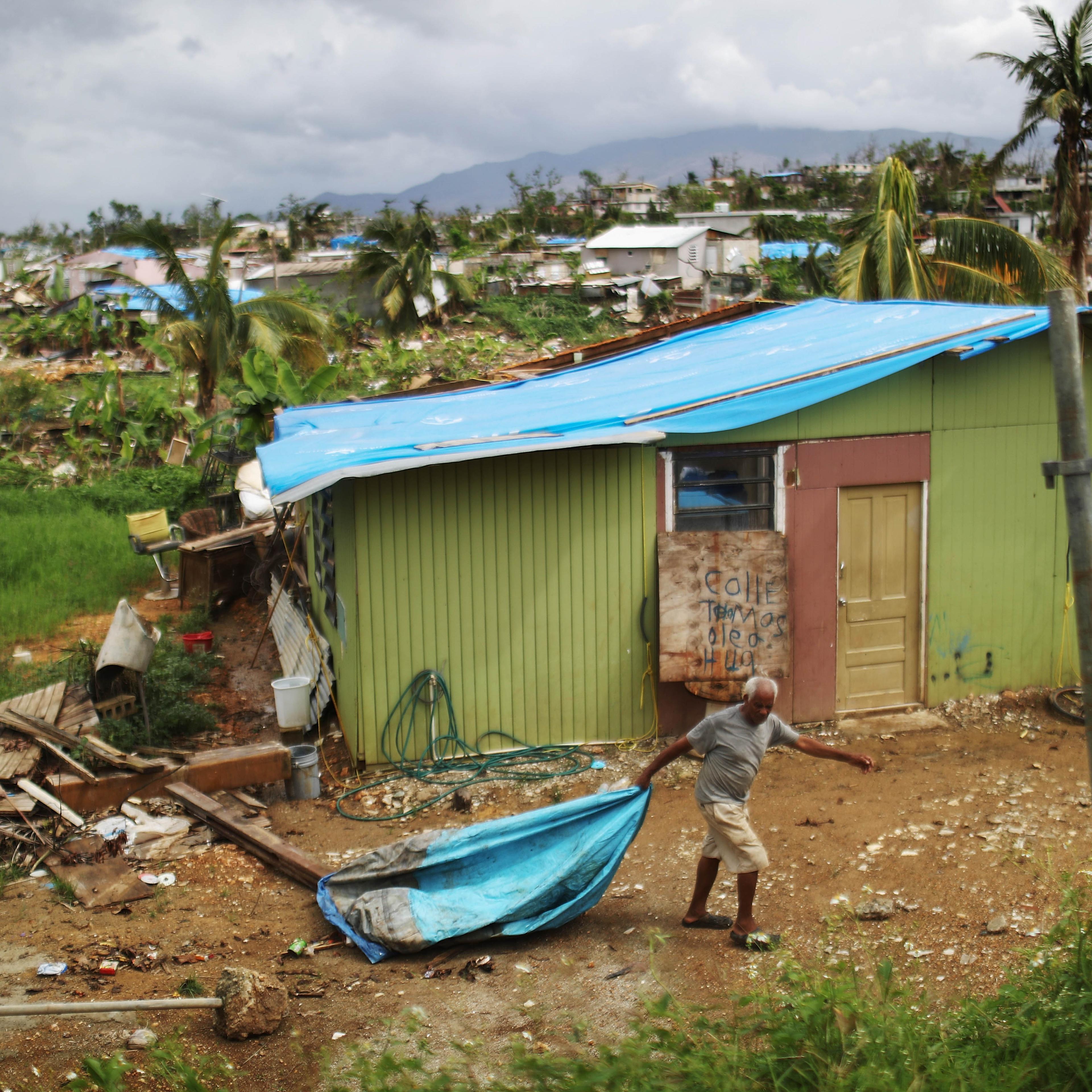 resident cleans debris near his damaged home puerto rico