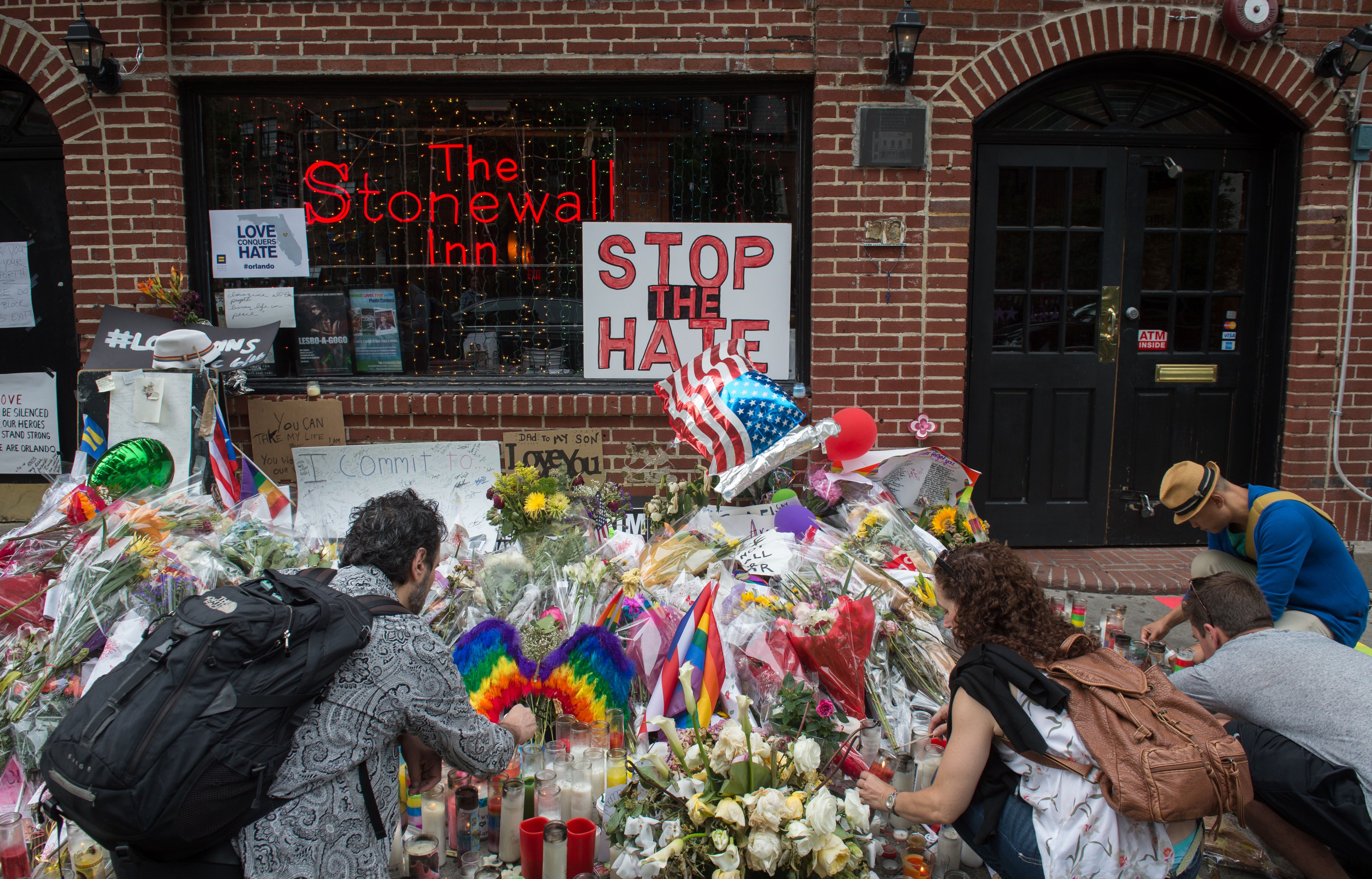 People light candles at a memorial to the Orlando shooting victims outside the Stonewall Inn in New York City on June 16, 2016.