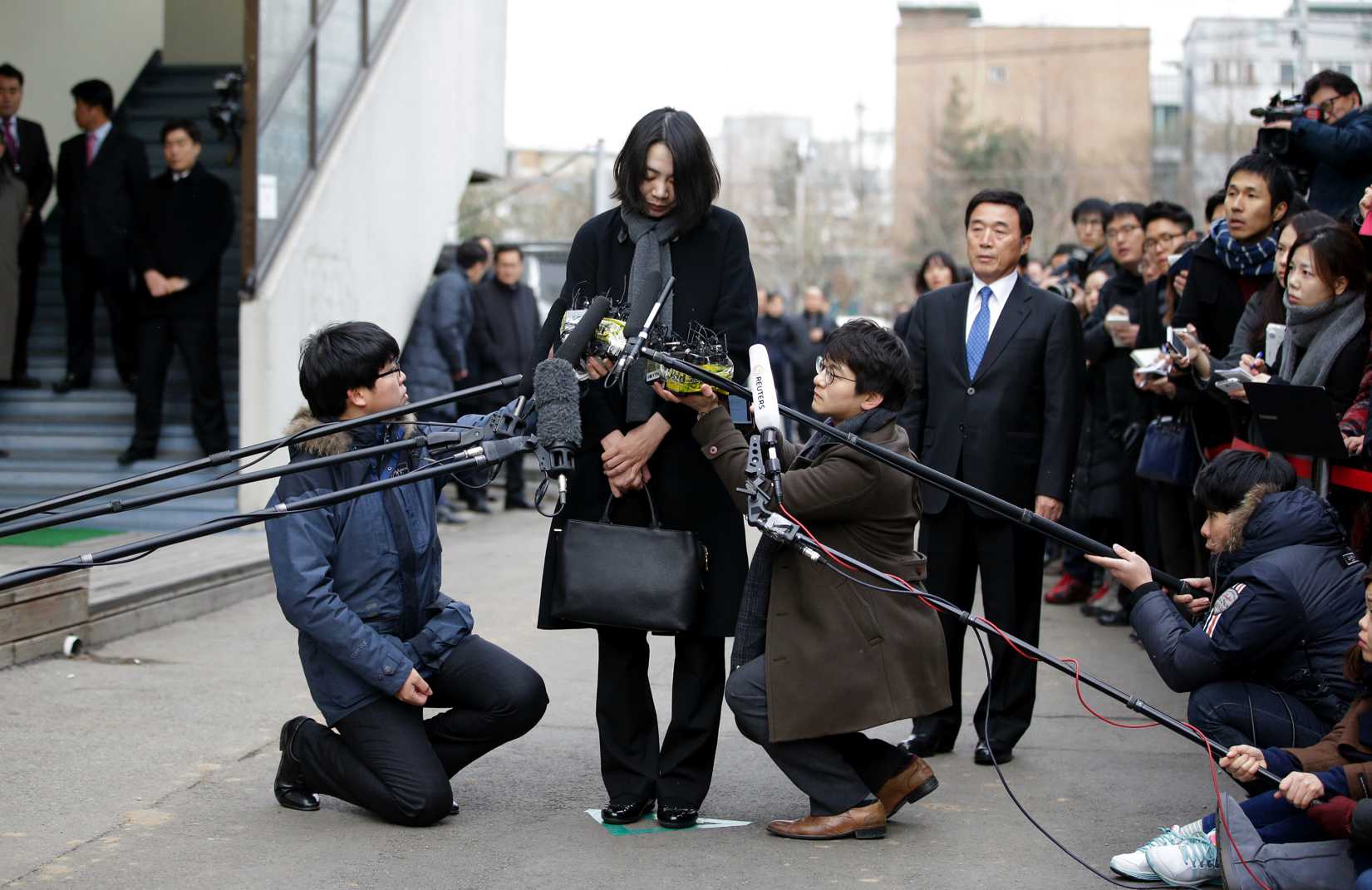 In this Friday, Dec. 12, 2014 photo, Cho Hyun-ah, who was head of cabin service at Korean Air and the oldest child of Korean Air chairman Cho Yang-ho, speaks to the media upon her arrival for questioning at the Aviation and Railway Accident Investigation Board office of Ministry of Land, Infrastructure and Transport in Seoul, South Korea.