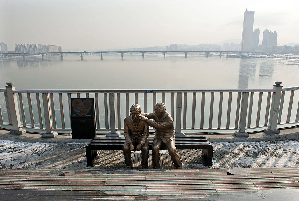 This photo taken on January 11, 2013 shows a statue of a man comforting a person placed by the government to dissuade potential suicides at Mapo Bridge—a common site for suicides—over Seoul's Han river.