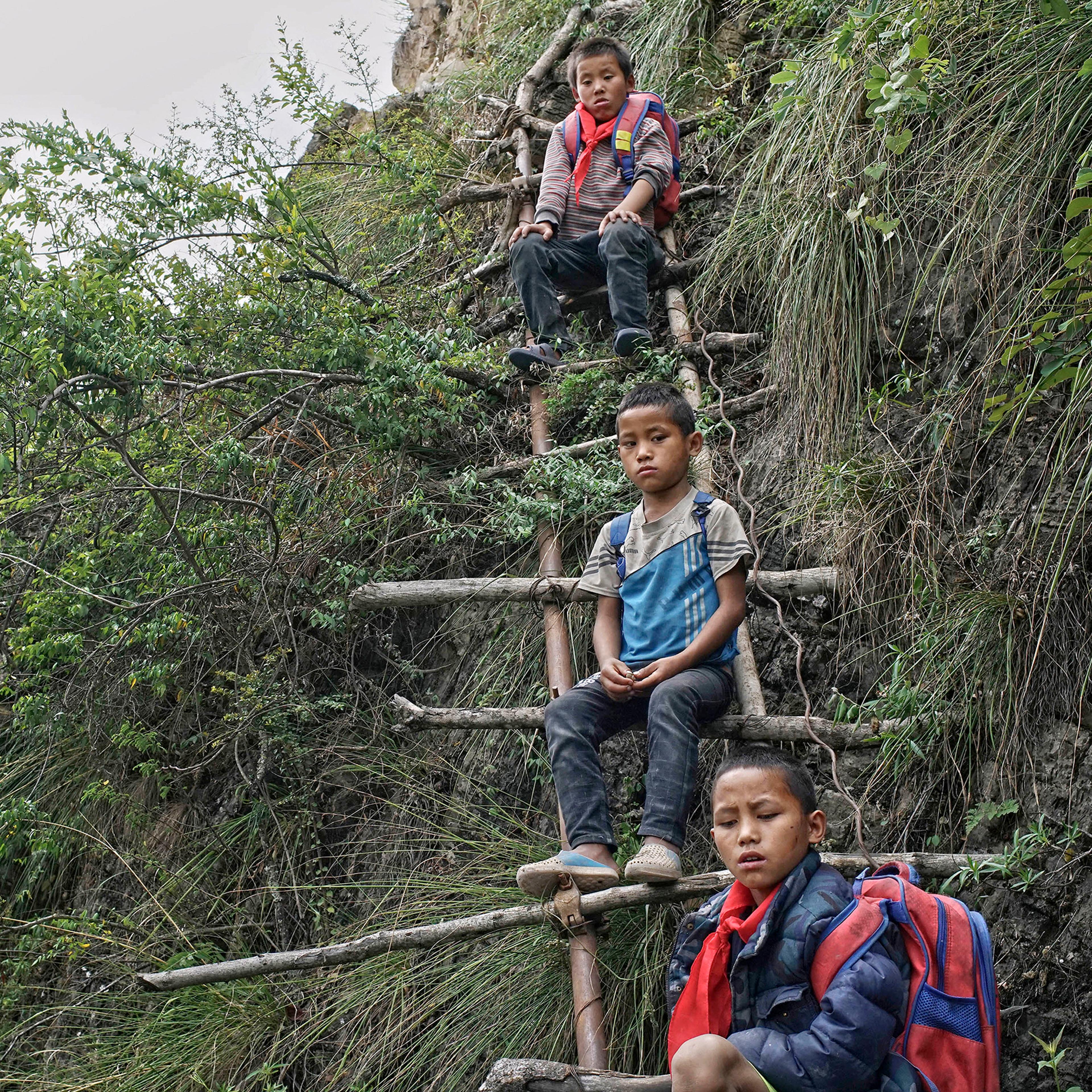 Children carrying their schoolbags take rest on the ladder built on a cliff in Zhaojue county, southwest China's Sichuan province on May 14, 2016.
