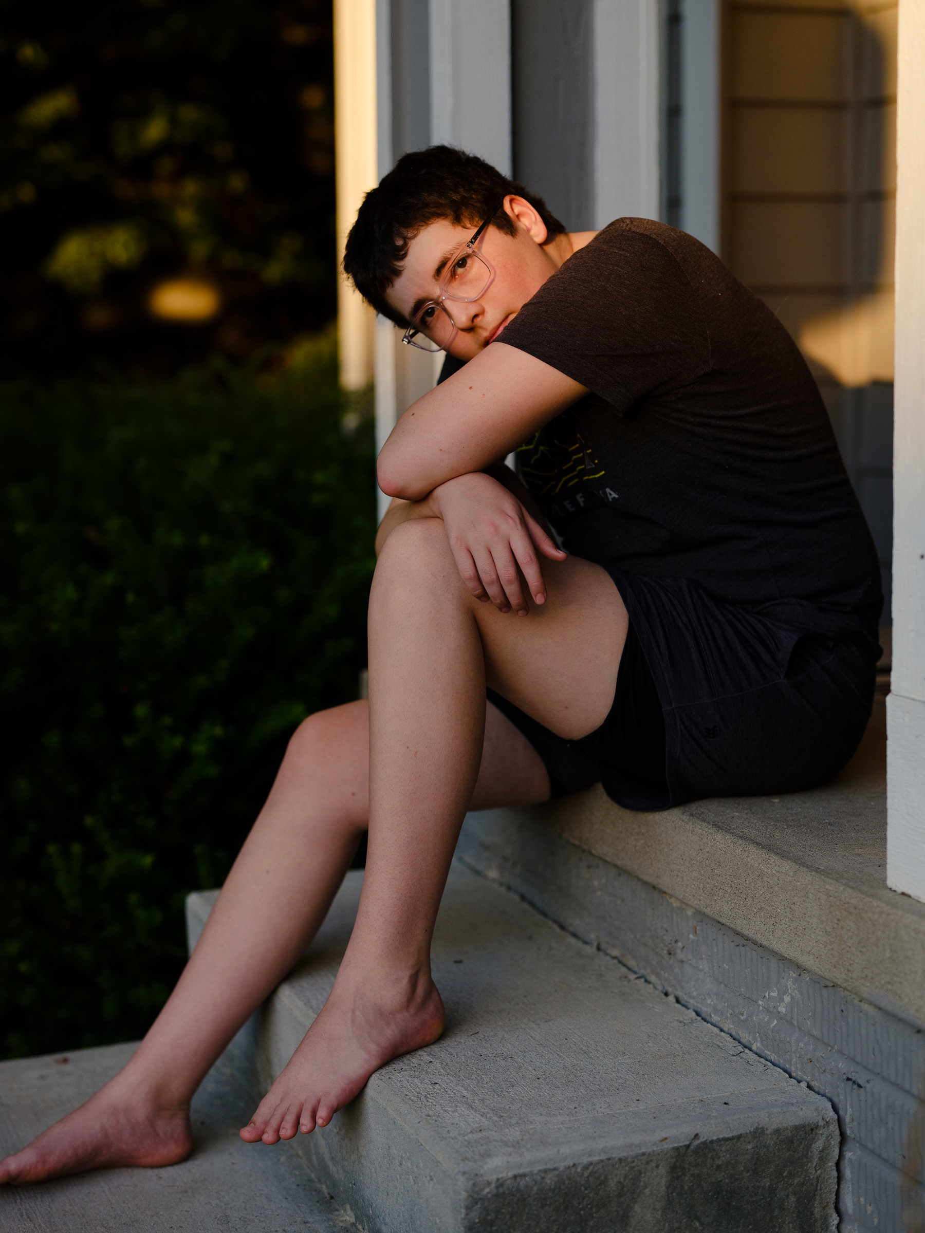 Petra, 18, sits on a stoop in her yard in Iowa.