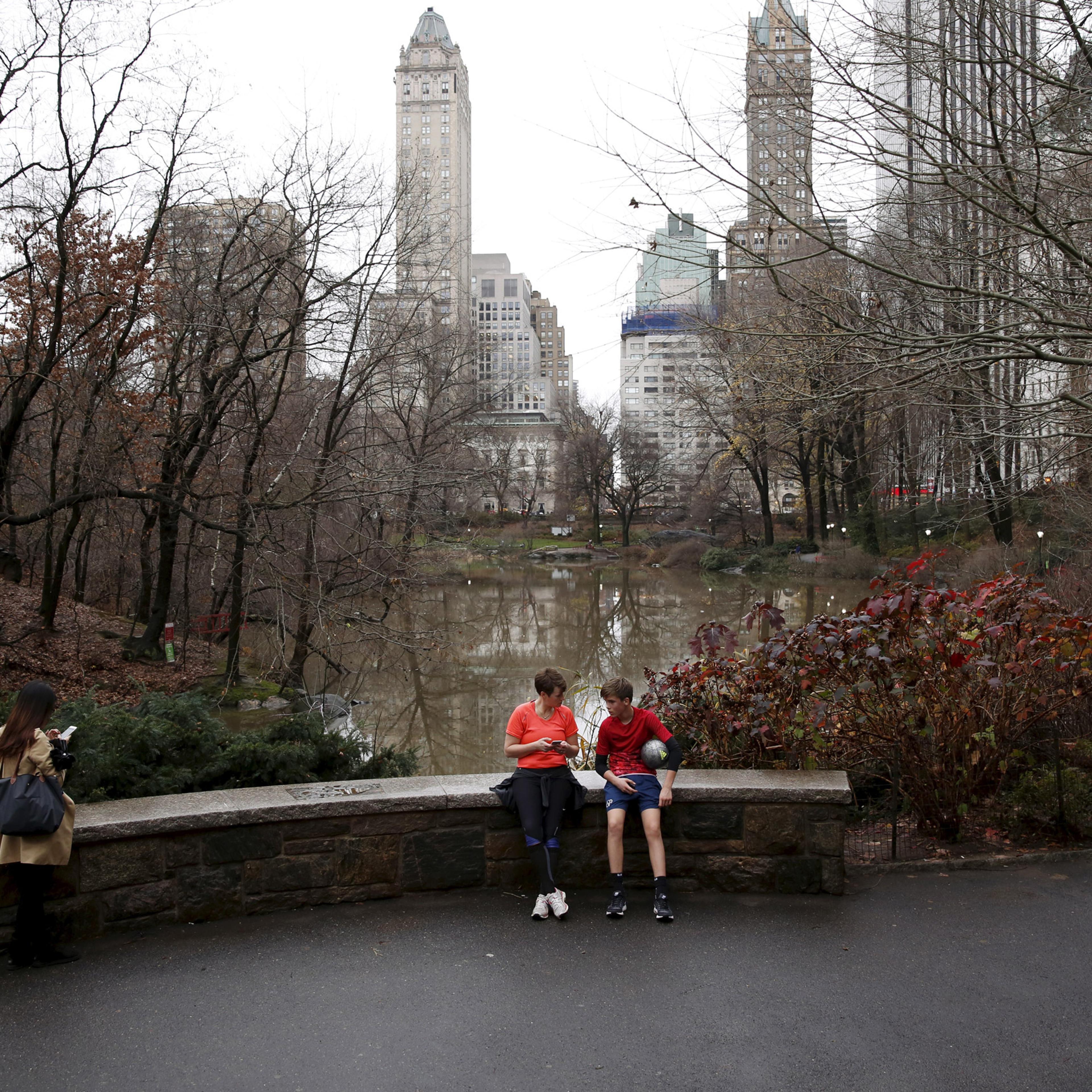 People sit to rest in Central Park during an unseasonably warm day in New York December 24, 2015. REUTERS/Lucas Jackson - RTX2005Q