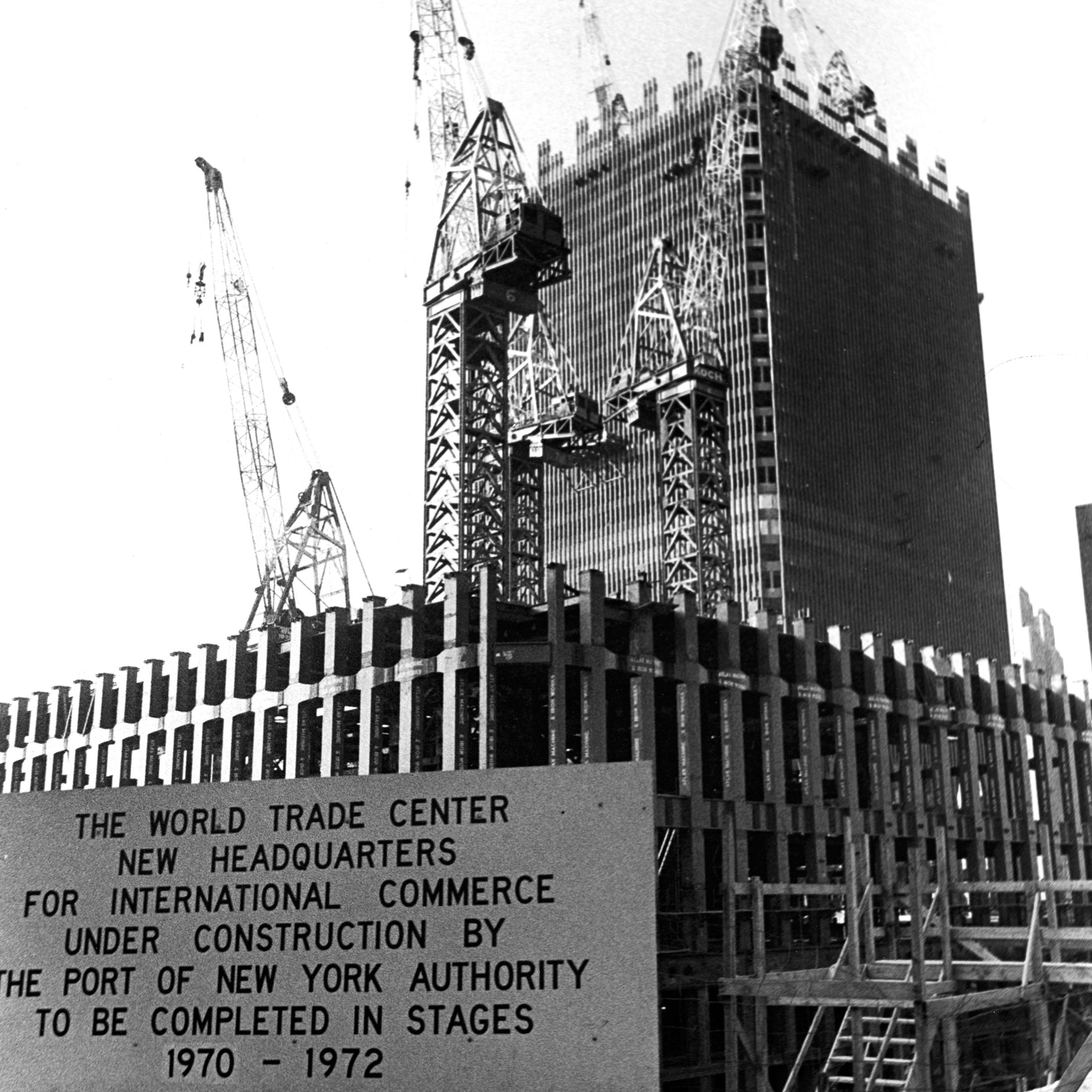 View of the World Trade Center under construction, with a sign announcing the completion schedule, circa 1969, New York City,