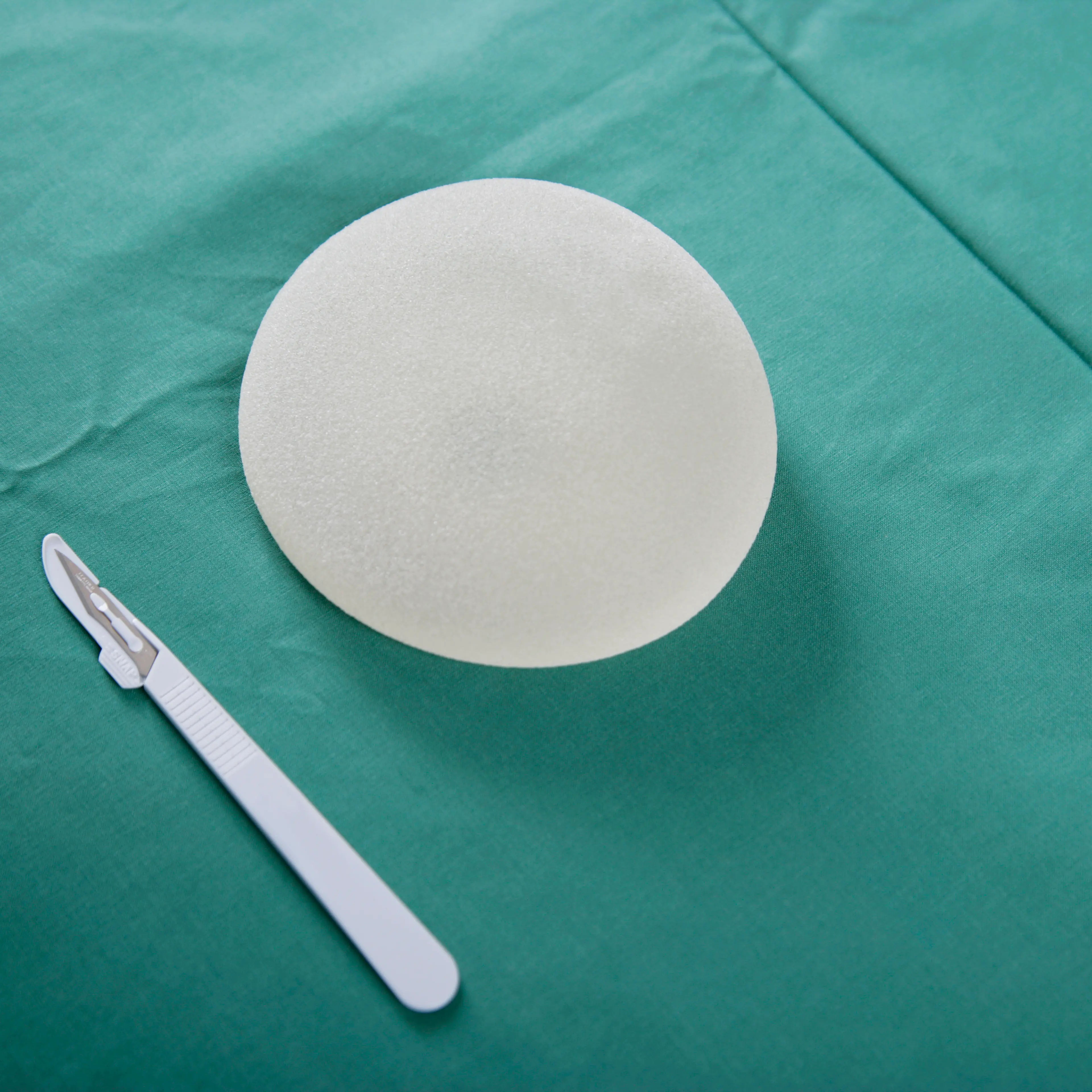 A breast implant and scalpel