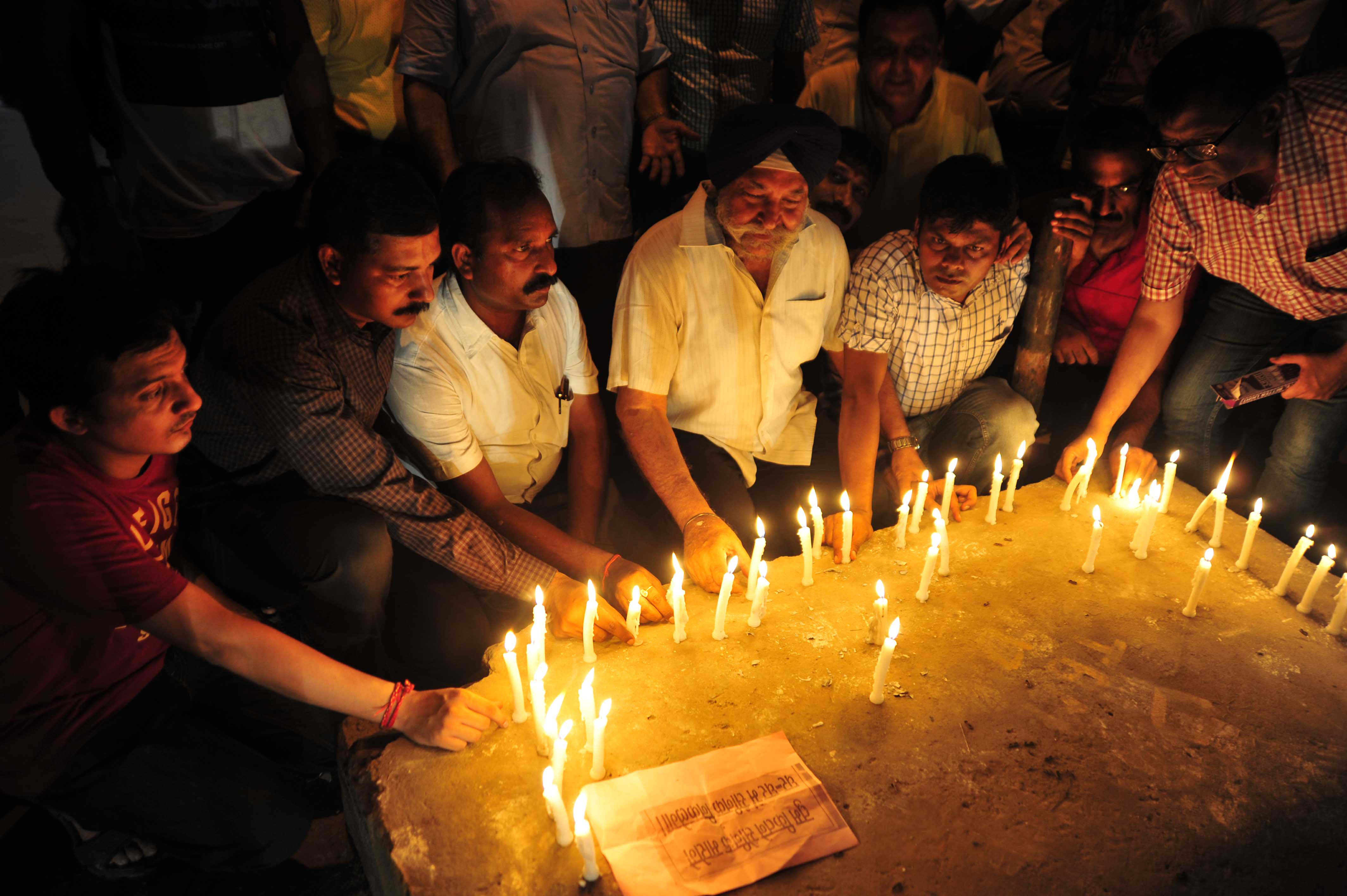People light candles during a protest against the attack on