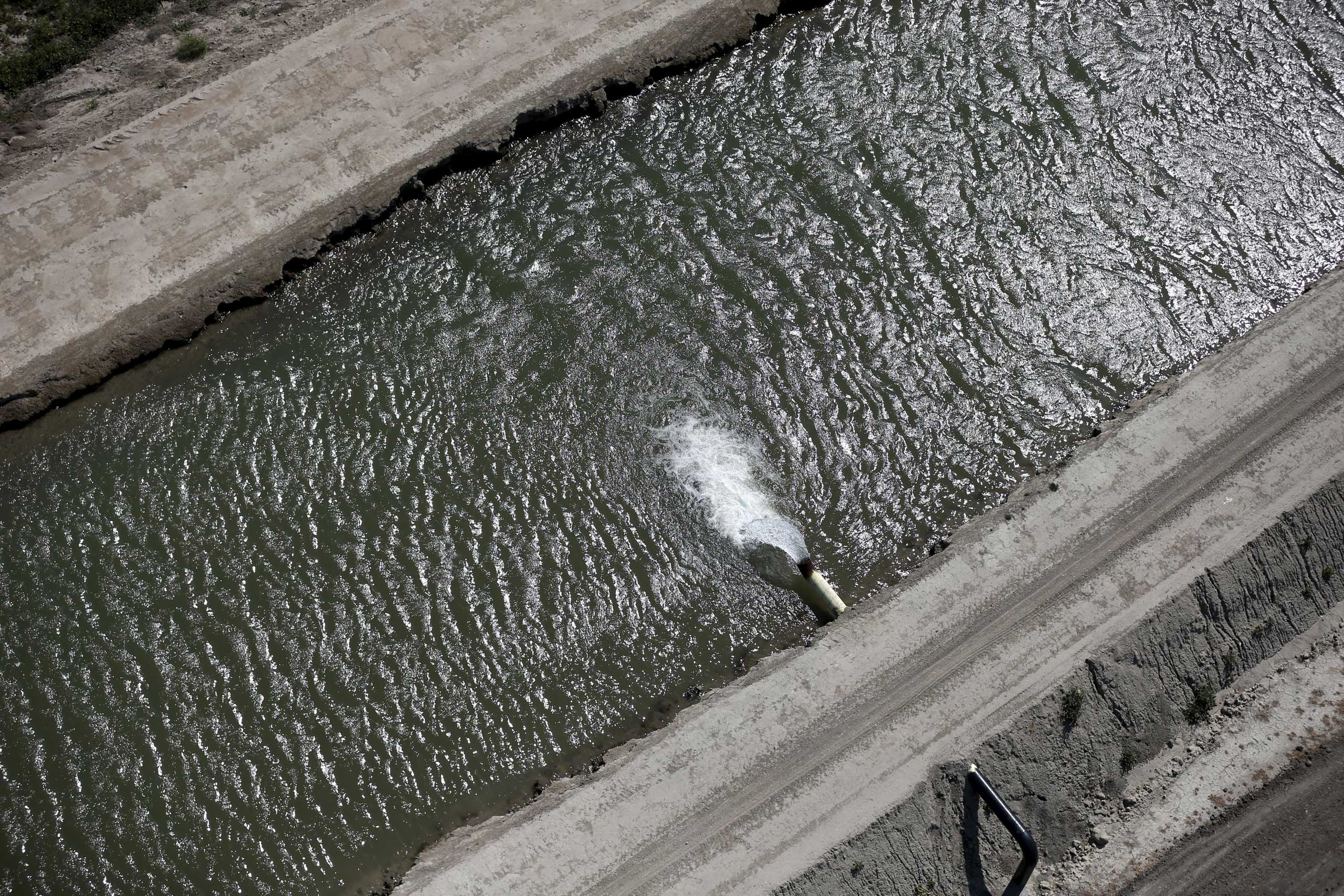 Water pours into a canal in Los Banos