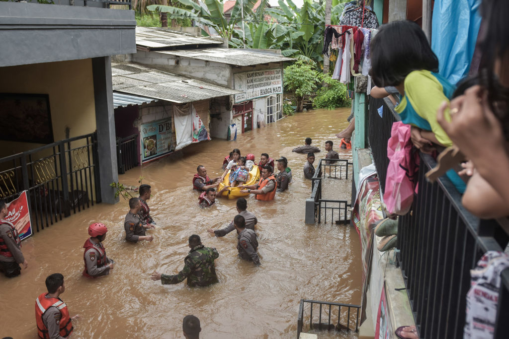 A rescue team evacuates residents from their flooded houses
