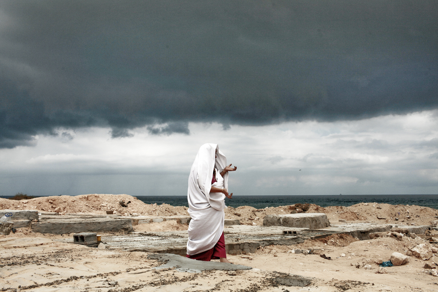 September 9, 2011. Under an ominous sky, Eyadea Elspaie visits the gravesite of his son, Tareq Elspaie, who was killed by Gafhafi loyalists last month, at a cemetery in Tripoli. Libyan rebels launched attacks on the loyalist holdouts of Bani Walid and Surt, and Interpol issued an arrest warrant for Col. Moammar Gadhafi.